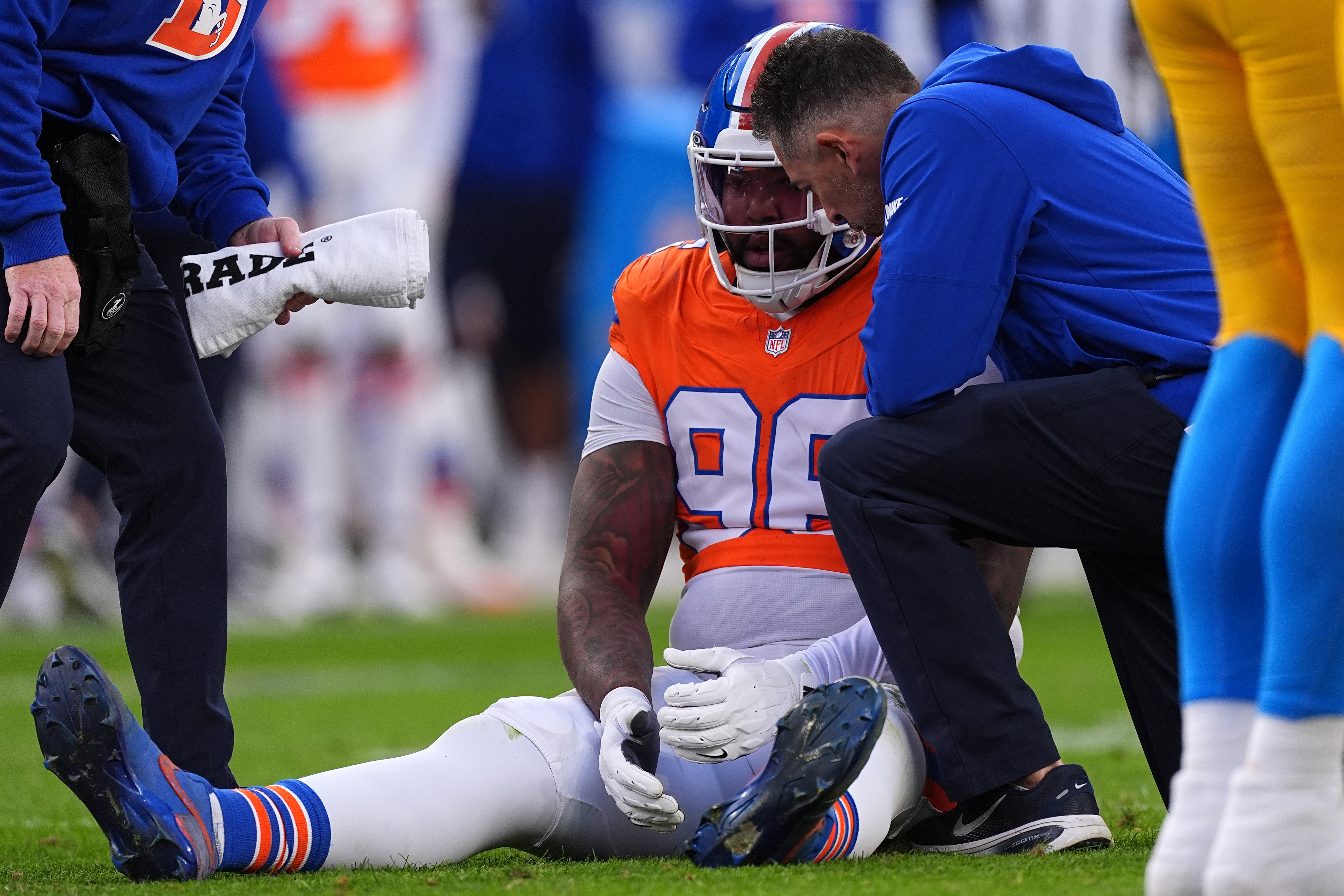 Trainers attend to Denver Broncos defensive end John Franklin-Myers (98)...