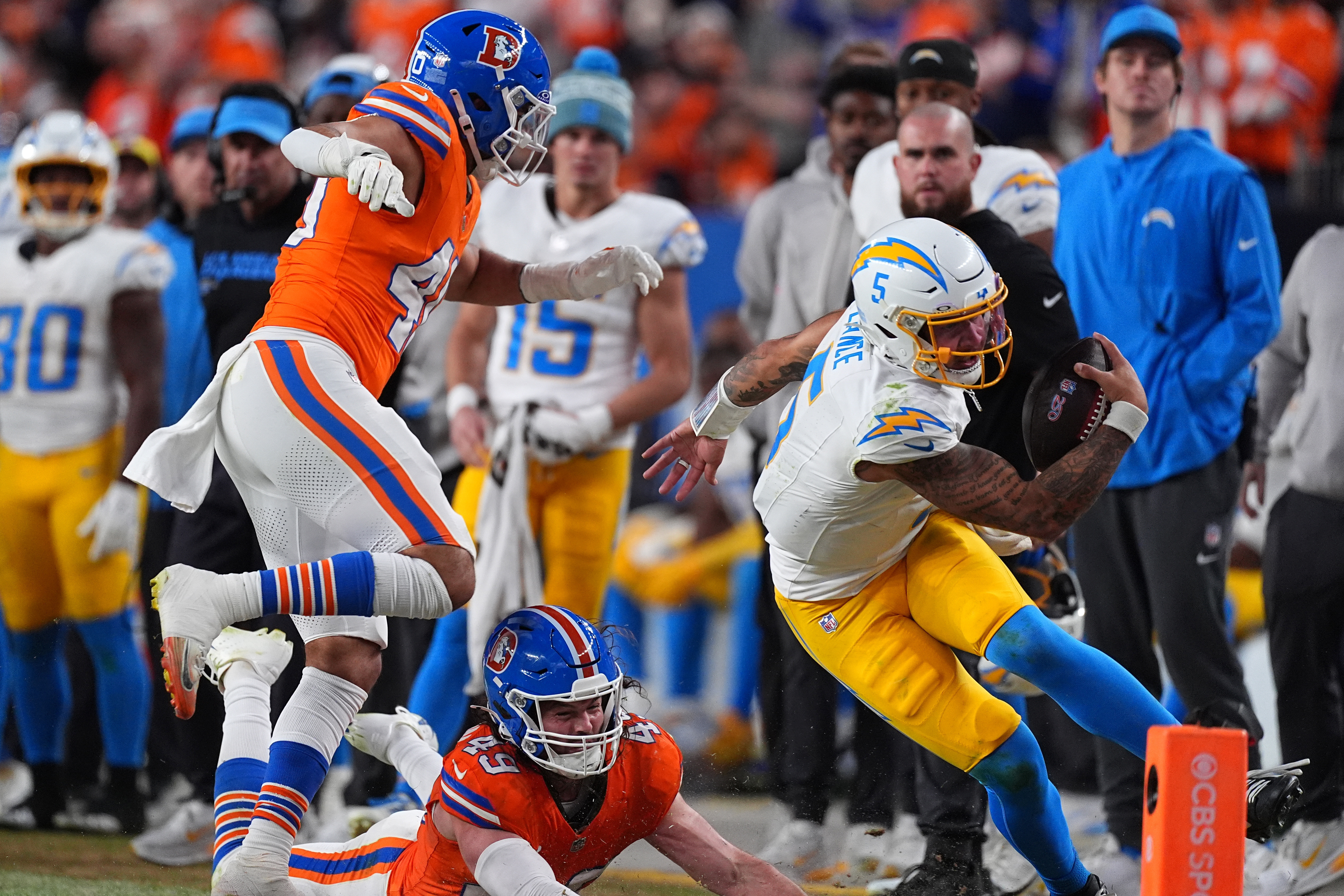Chargers quarterback Trey Lance, right, runs against Denver Broncos linebacker...