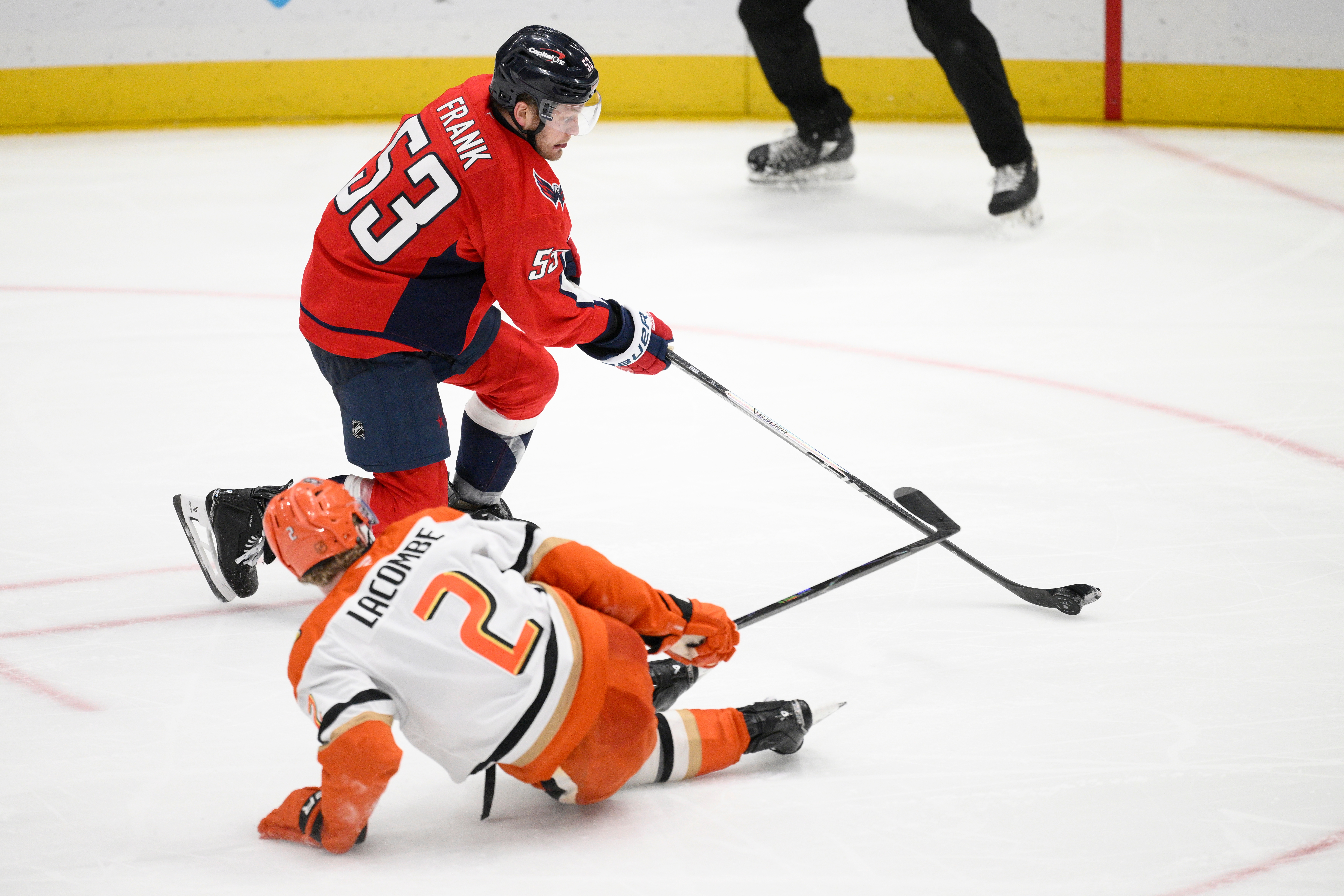 Washington Capitals center Ethen Frank, top, skates with the puck...