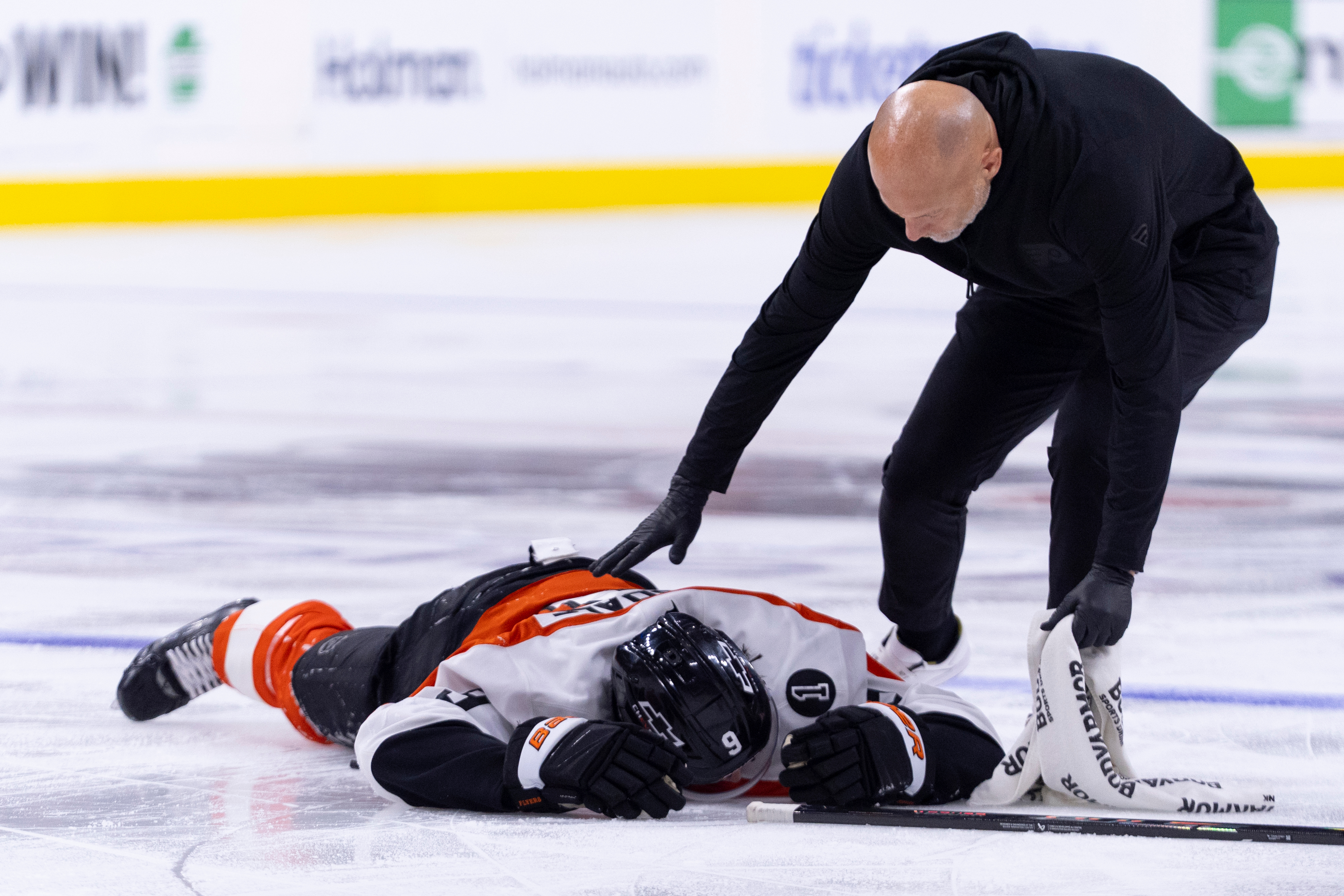 The Philadelphia Flyers’ Jamie Drysdale, left, lays on the ice...