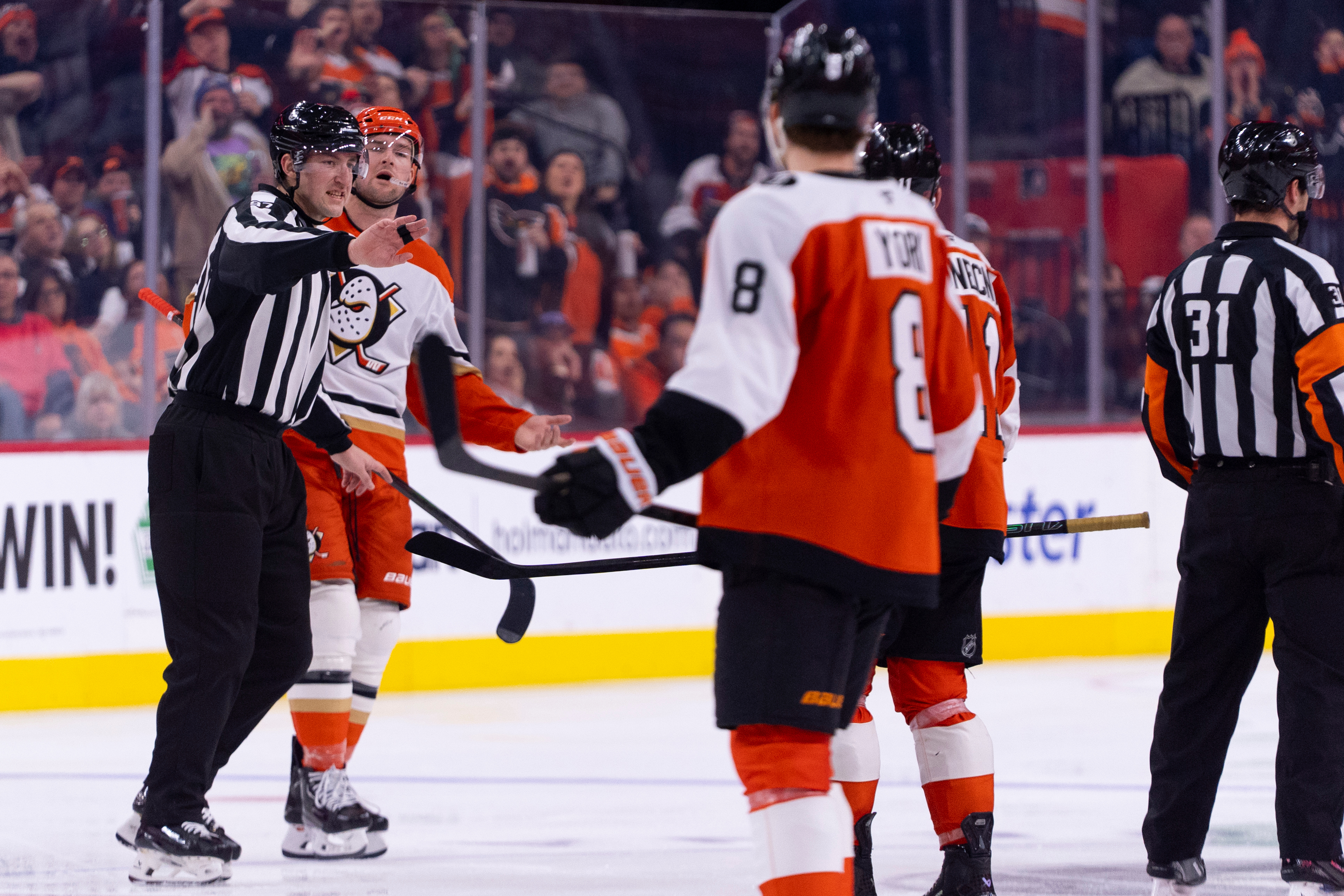 The Ducks’ Ross Johnston, second from left, gets escorted off...