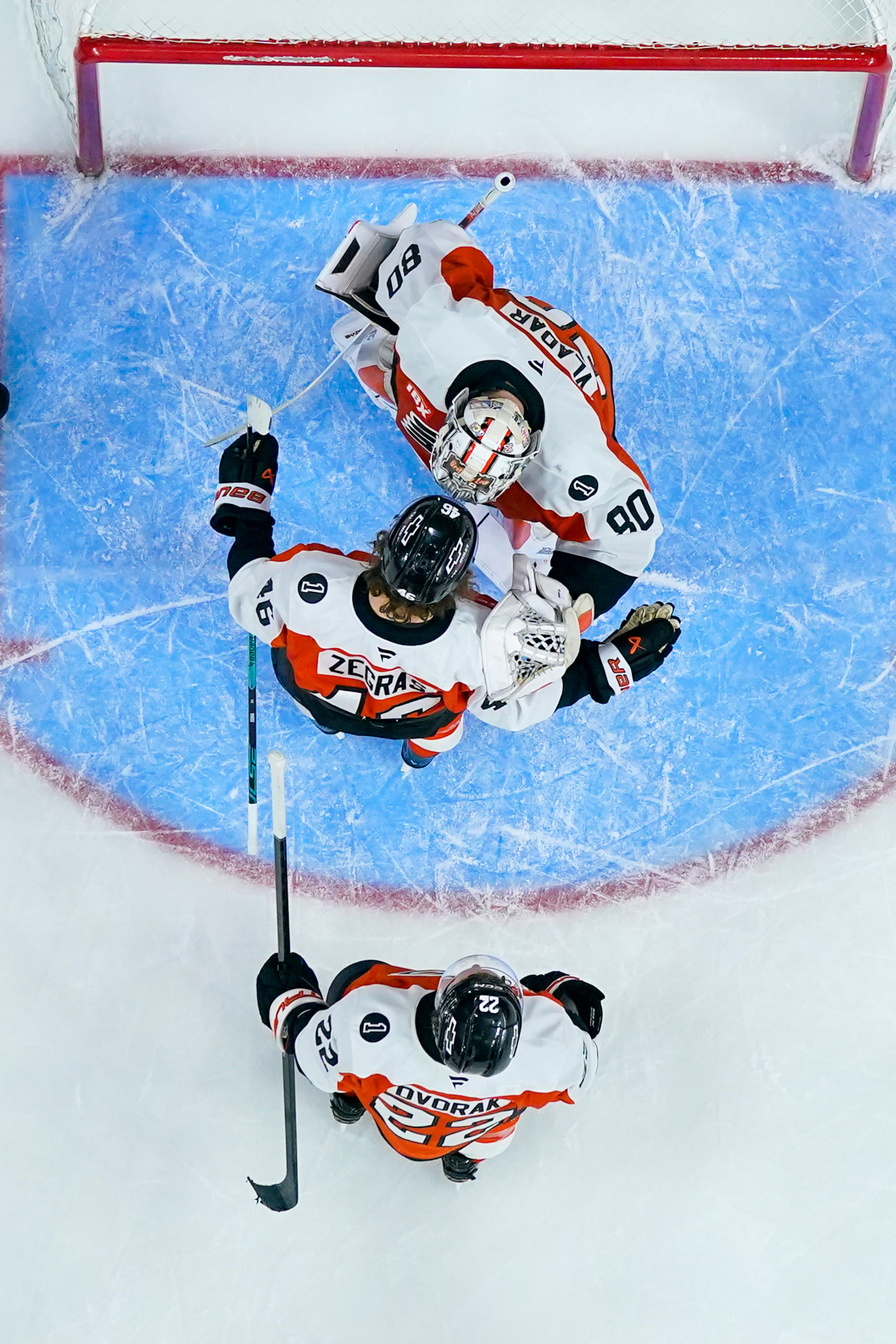 Philadelphia Flyers goaltender Dan Vladar, top, celebrates with teammates Trevor...