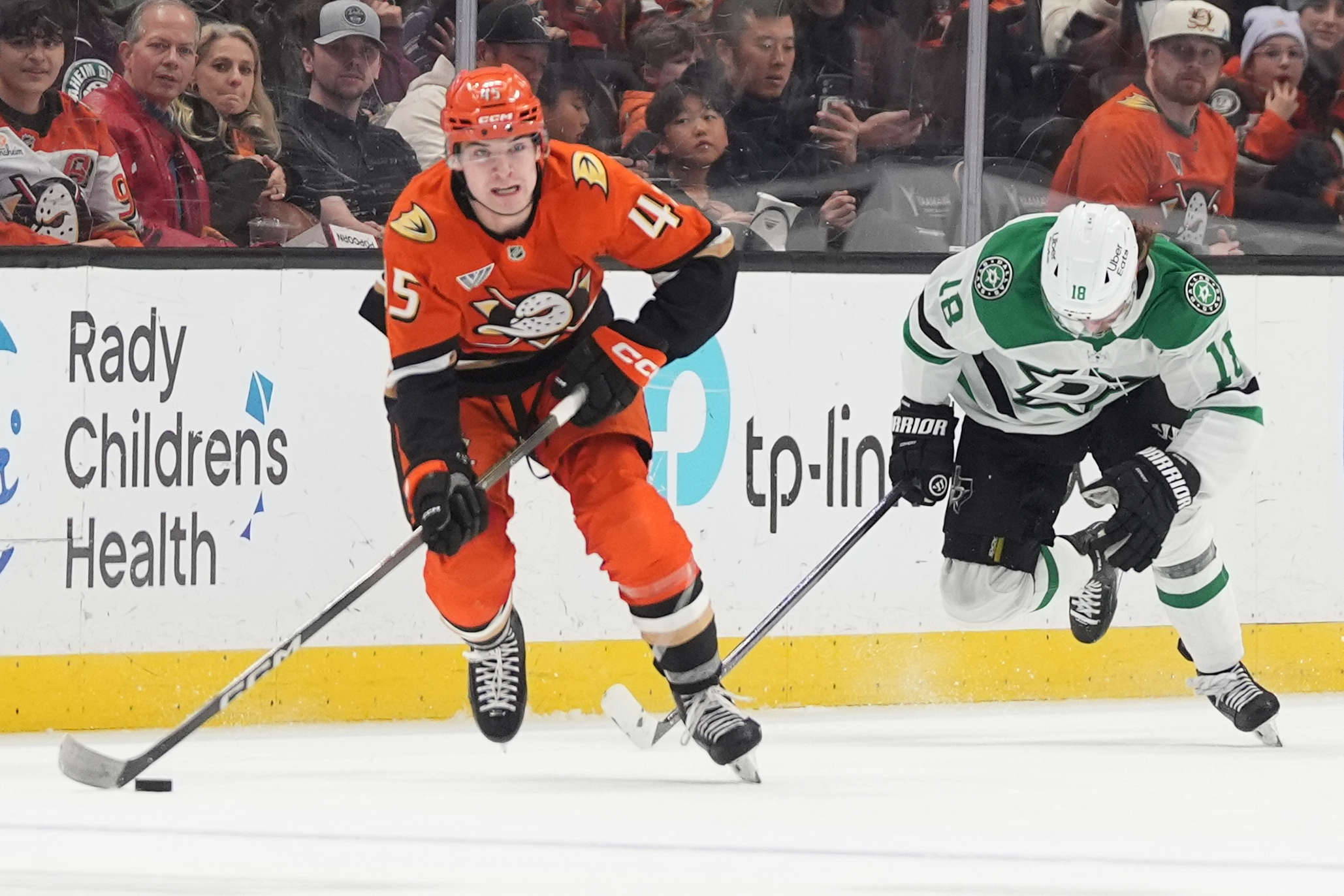 Ducks right wing Beckett Sennecke, left, passes the puck as...