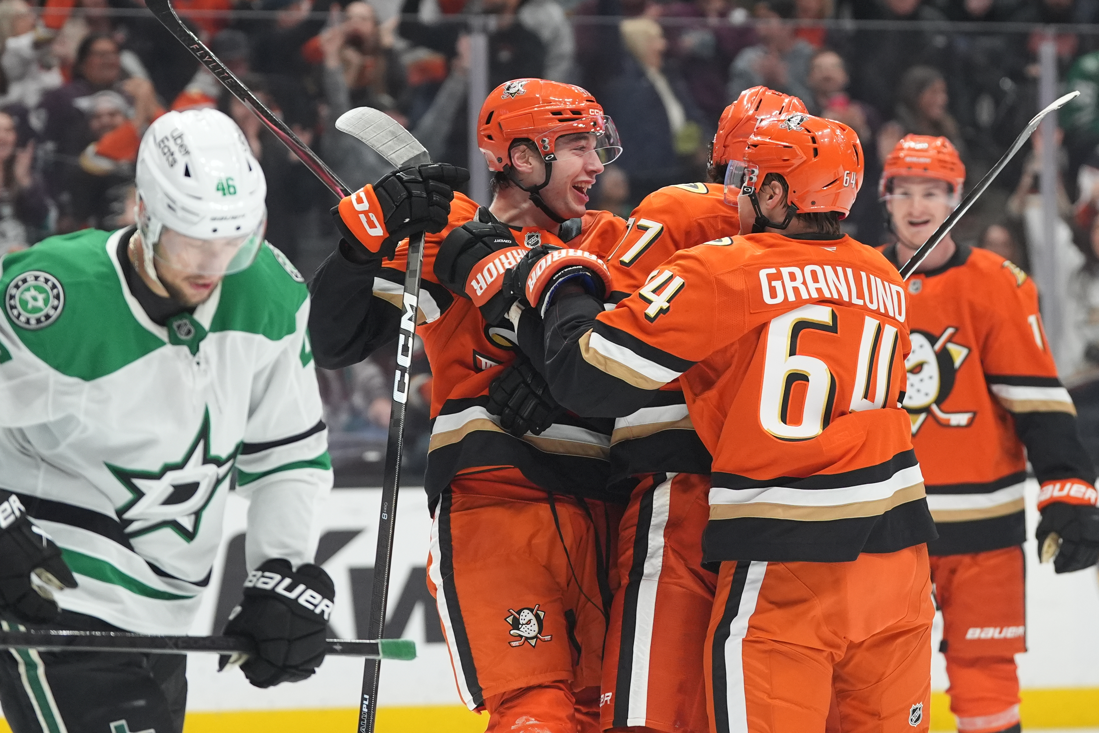 Ducks right wing Beckett Sennecke, center, celebrates his goal with...