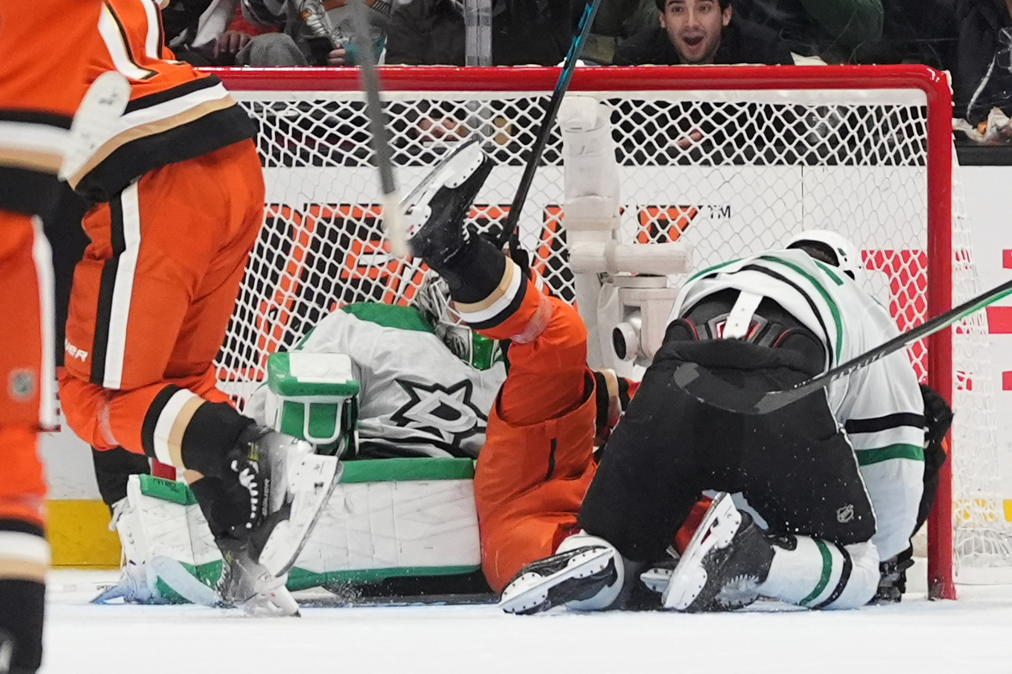 Ducks center Ryan Poehling, center, falls over Dallas Stars goaltender...