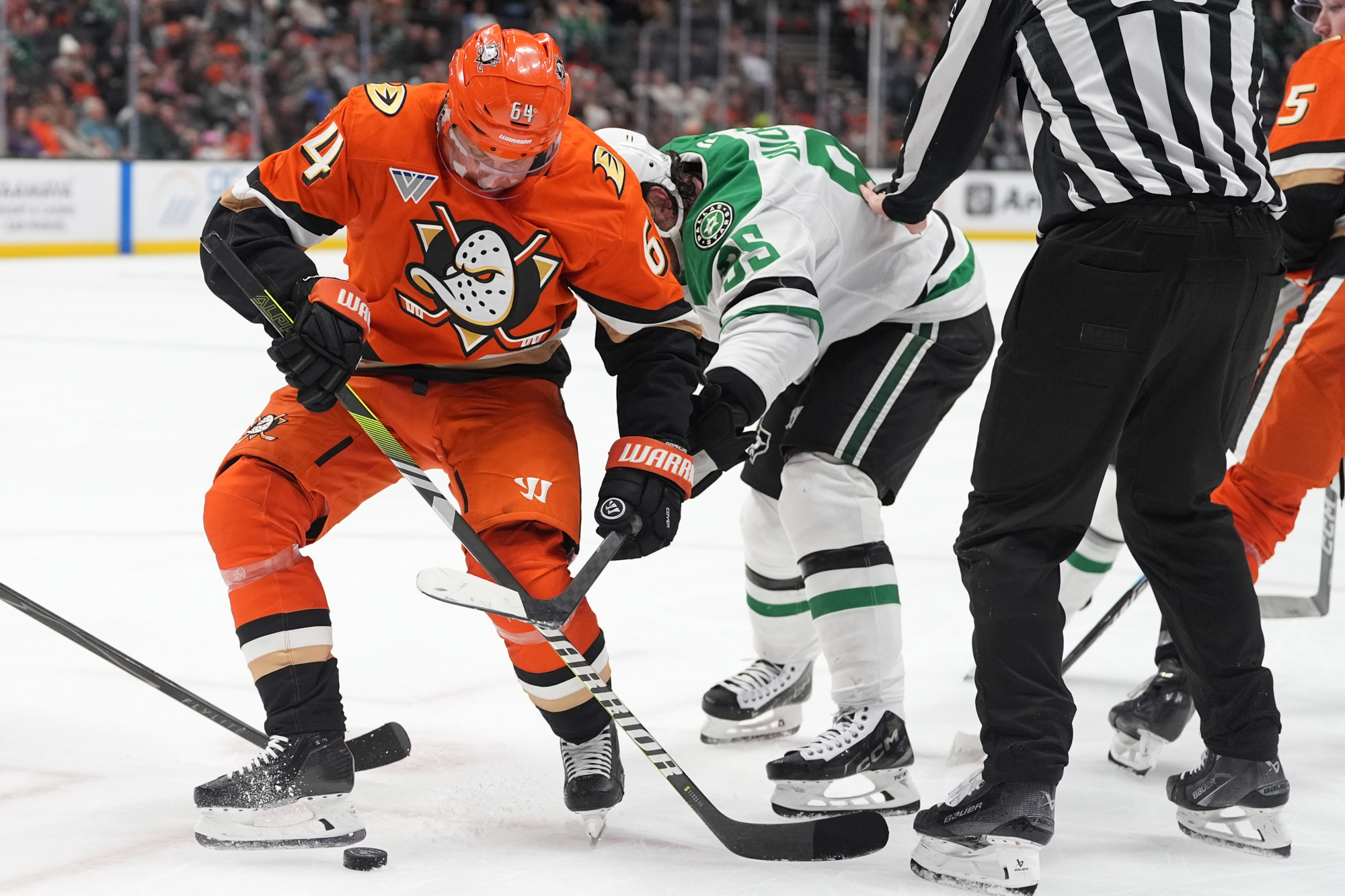 Ducks center Mikael Granlund, left, kicks the puck ahead of...
