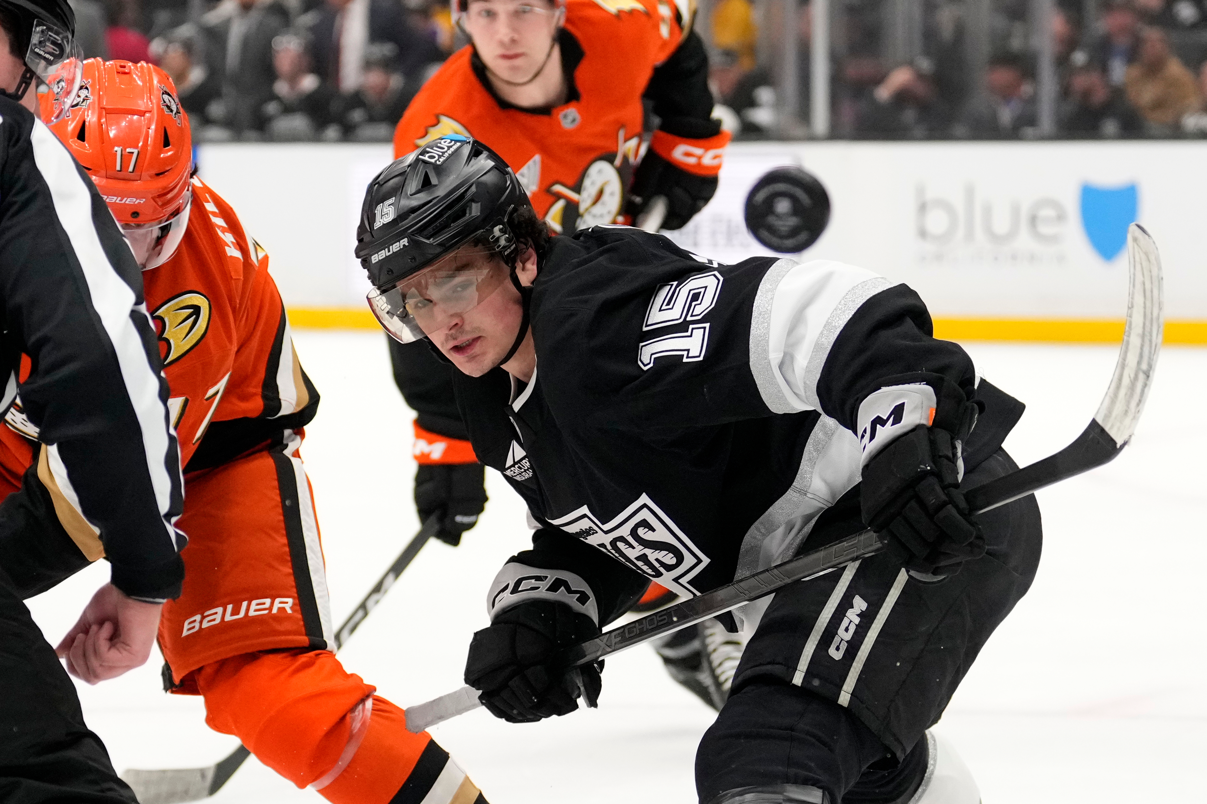 Kings center Alex Turcotte, right, watches the puck fly away...