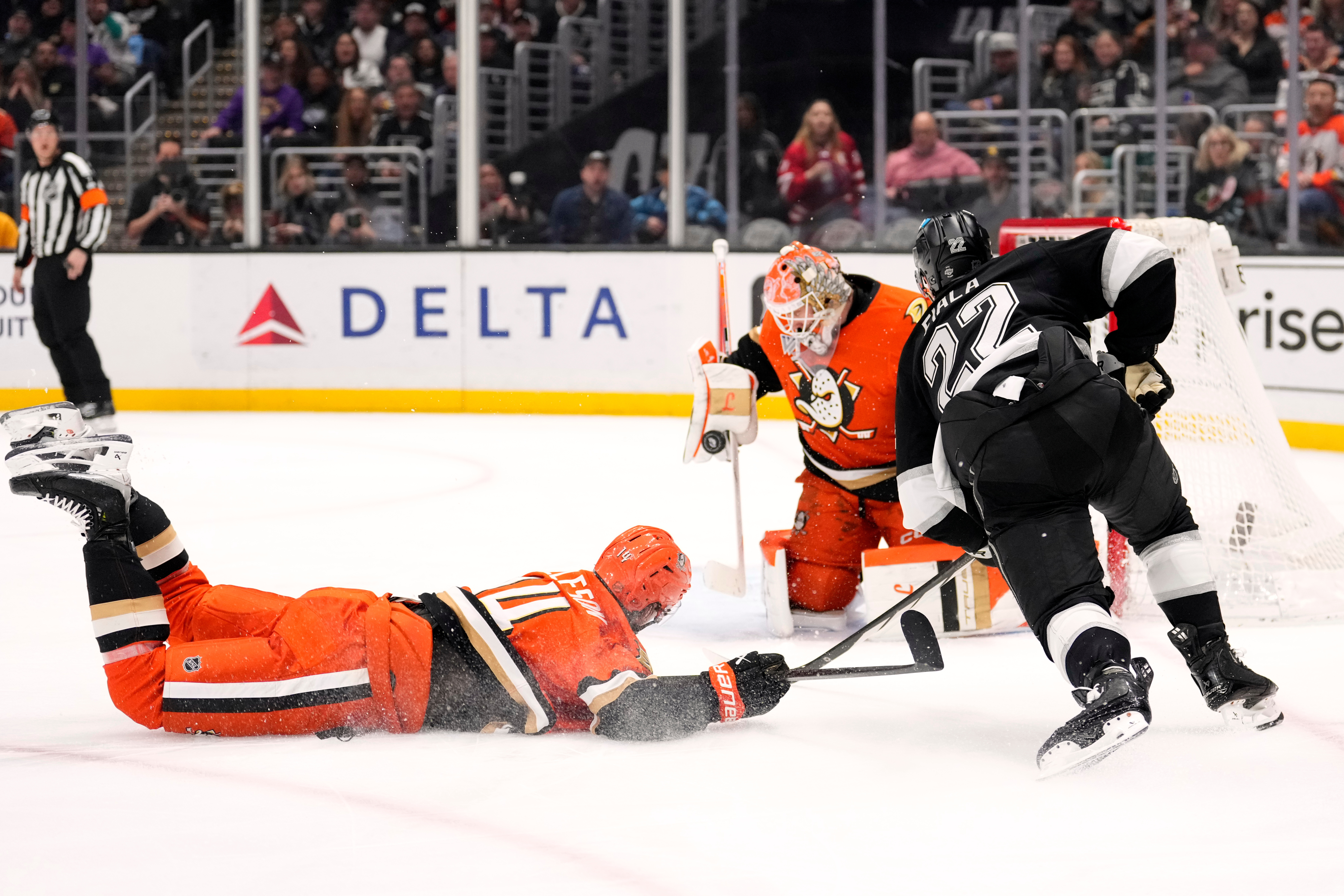 Ducks goaltender Lukas Dostal, center, stops a shot by Kings...
