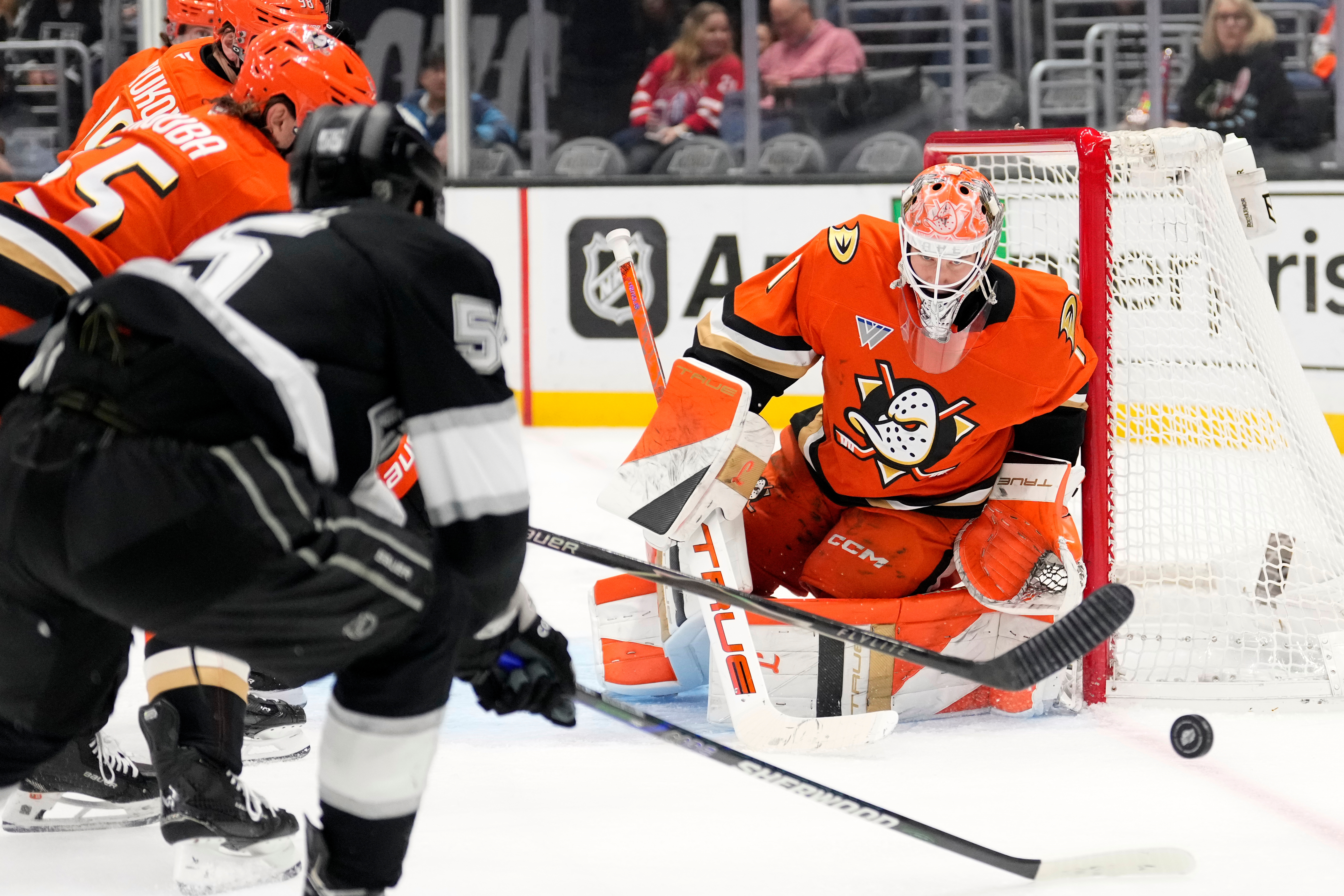 Ducks goaltender Lukas Dostal, right, stops a shot by Kings...