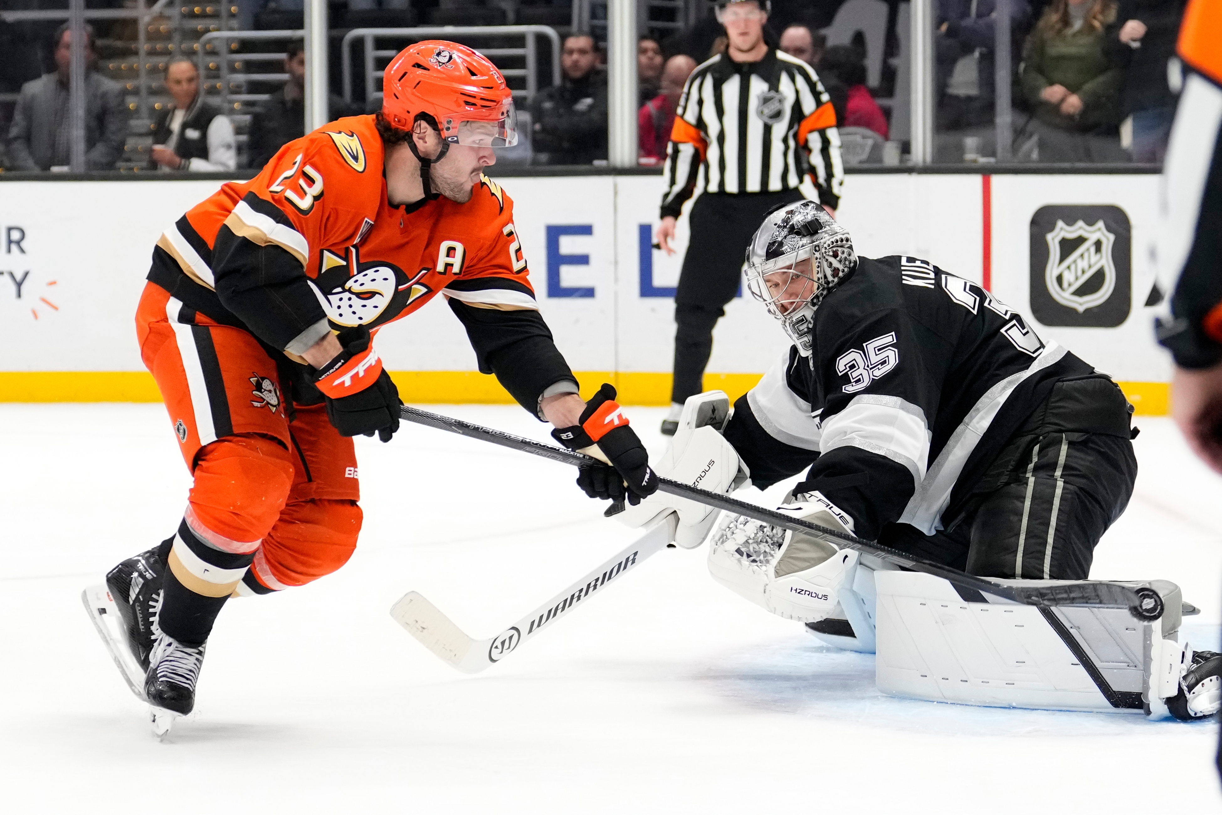 Ducks center Mason McTavish, left, scores on Kings goaltender Darcy...
