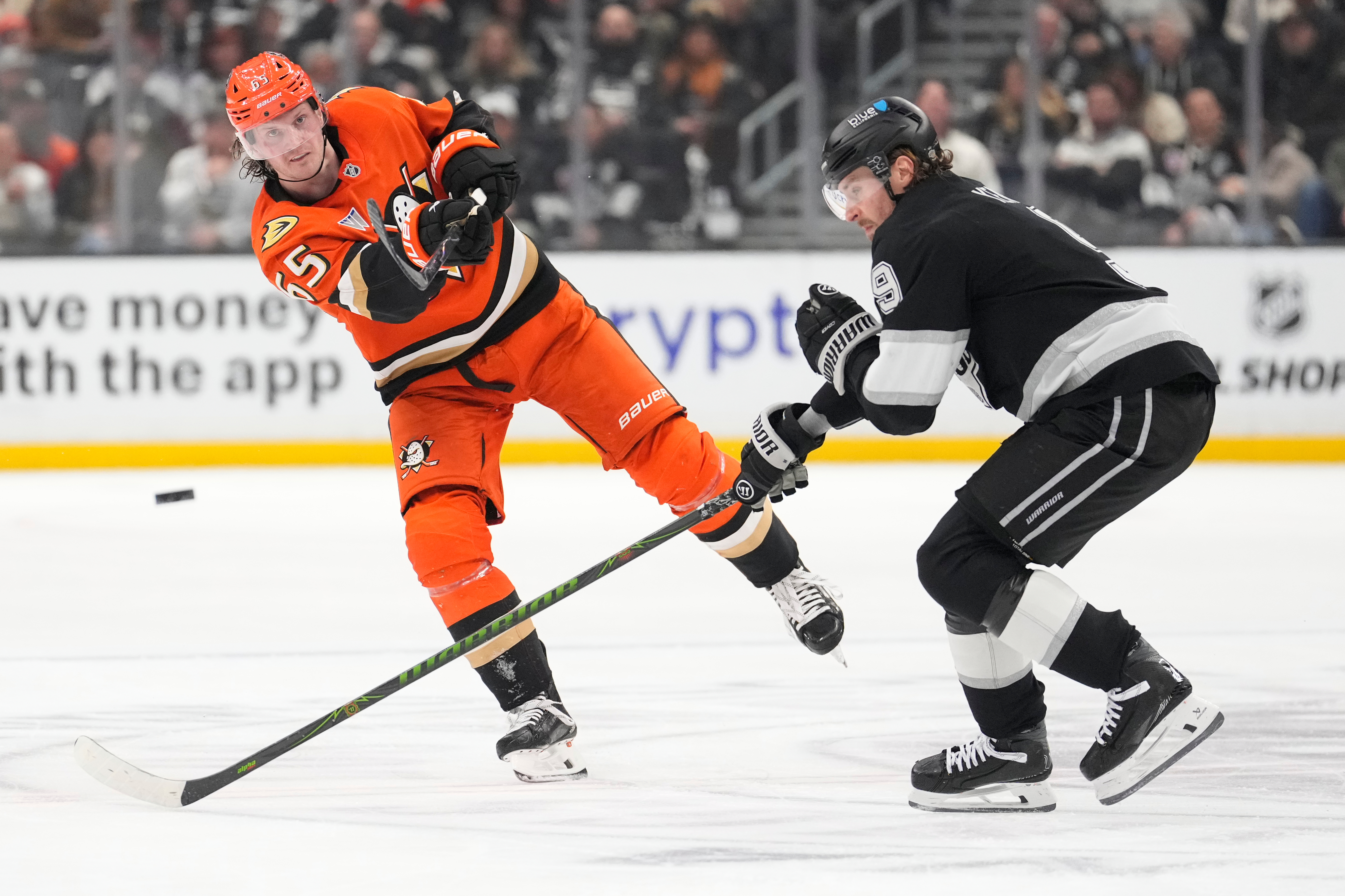 Ducks defenseman Jacob Trouba, left, passes the puck as Kings...