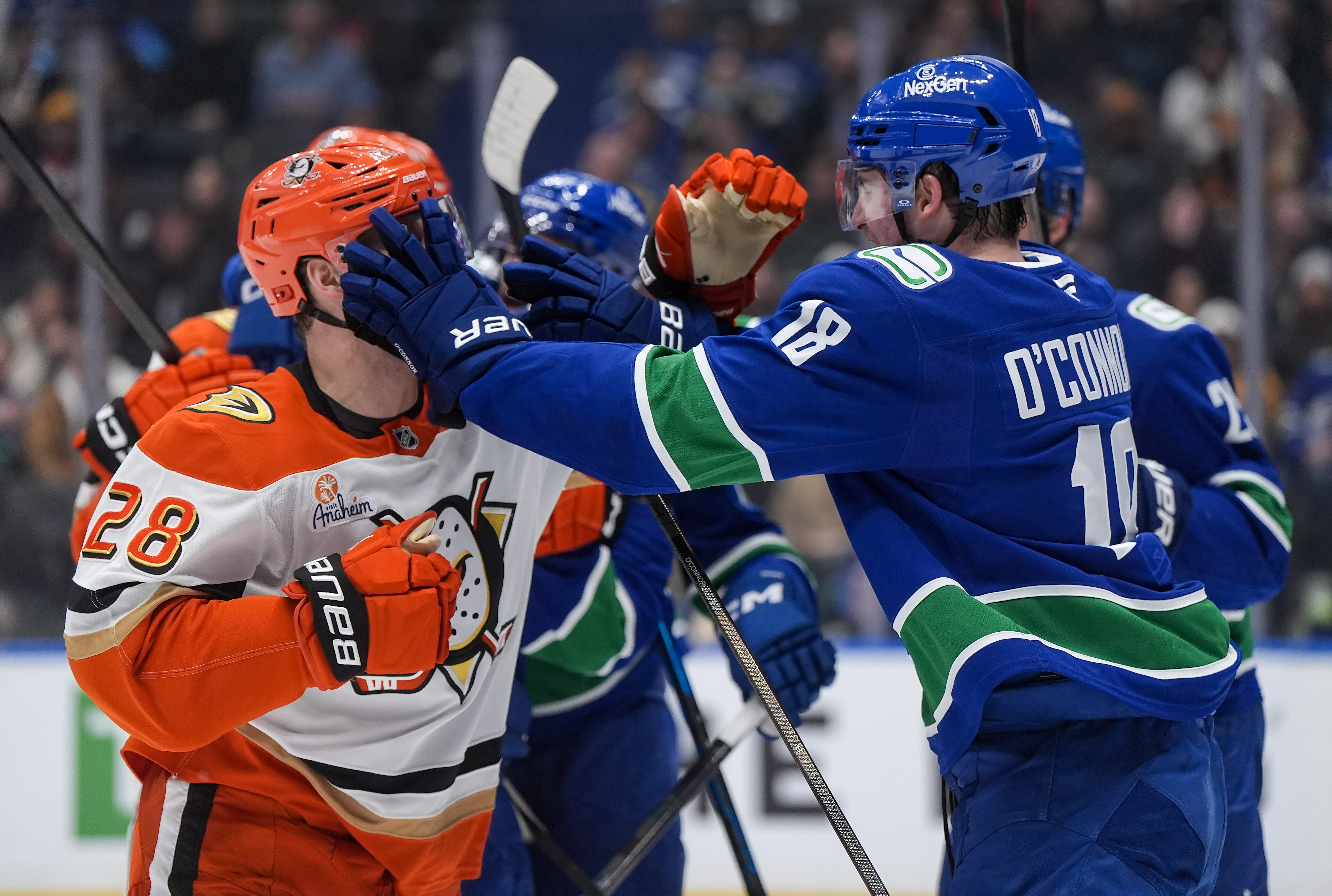 The Vancouver Canucks’ Drew O’Connor, right, and the Ducks’ Jeffrey...