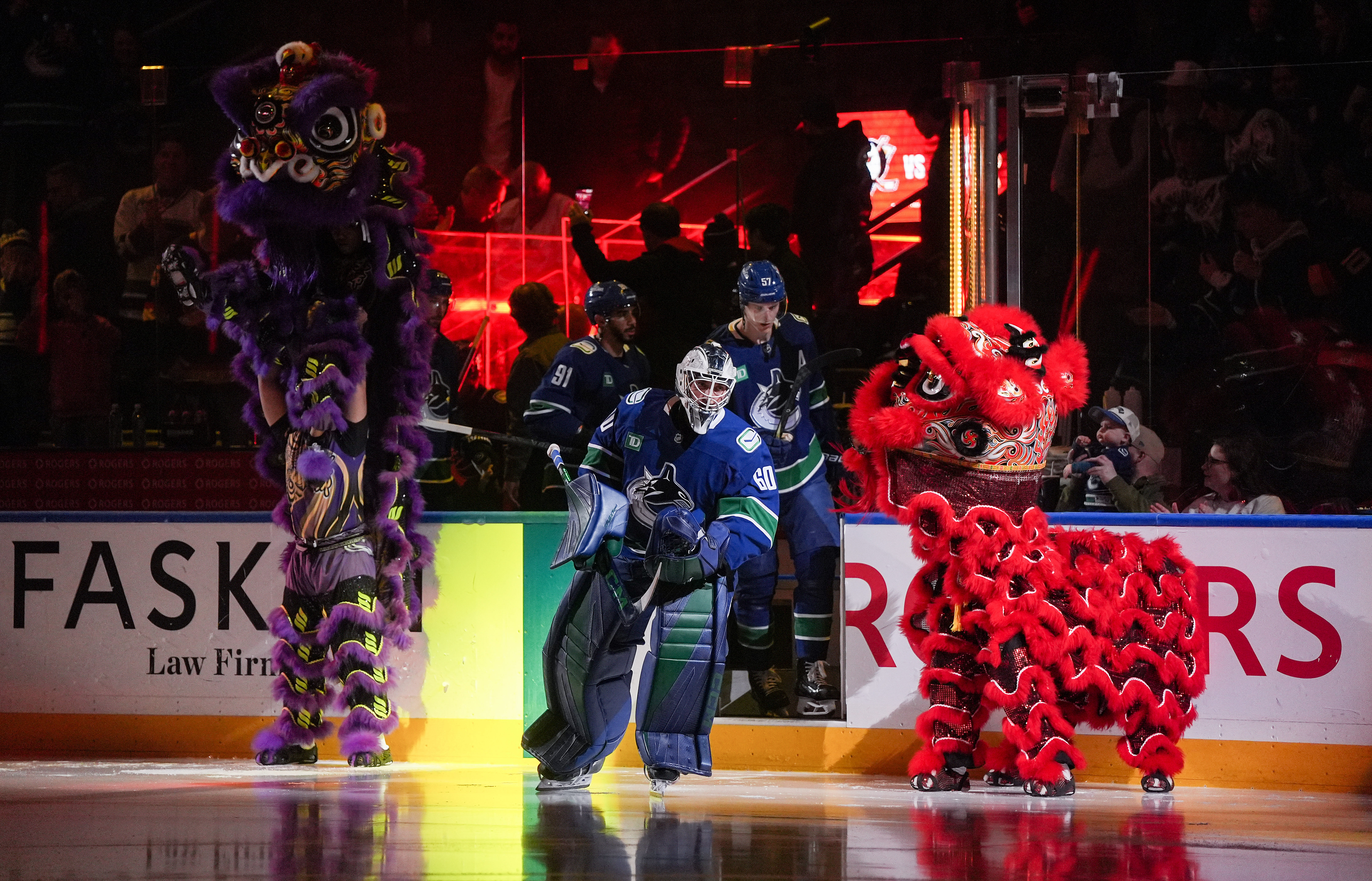 Vancouver Canucks goalie Nikita Tolopilo, center, skates past Chinese lion...