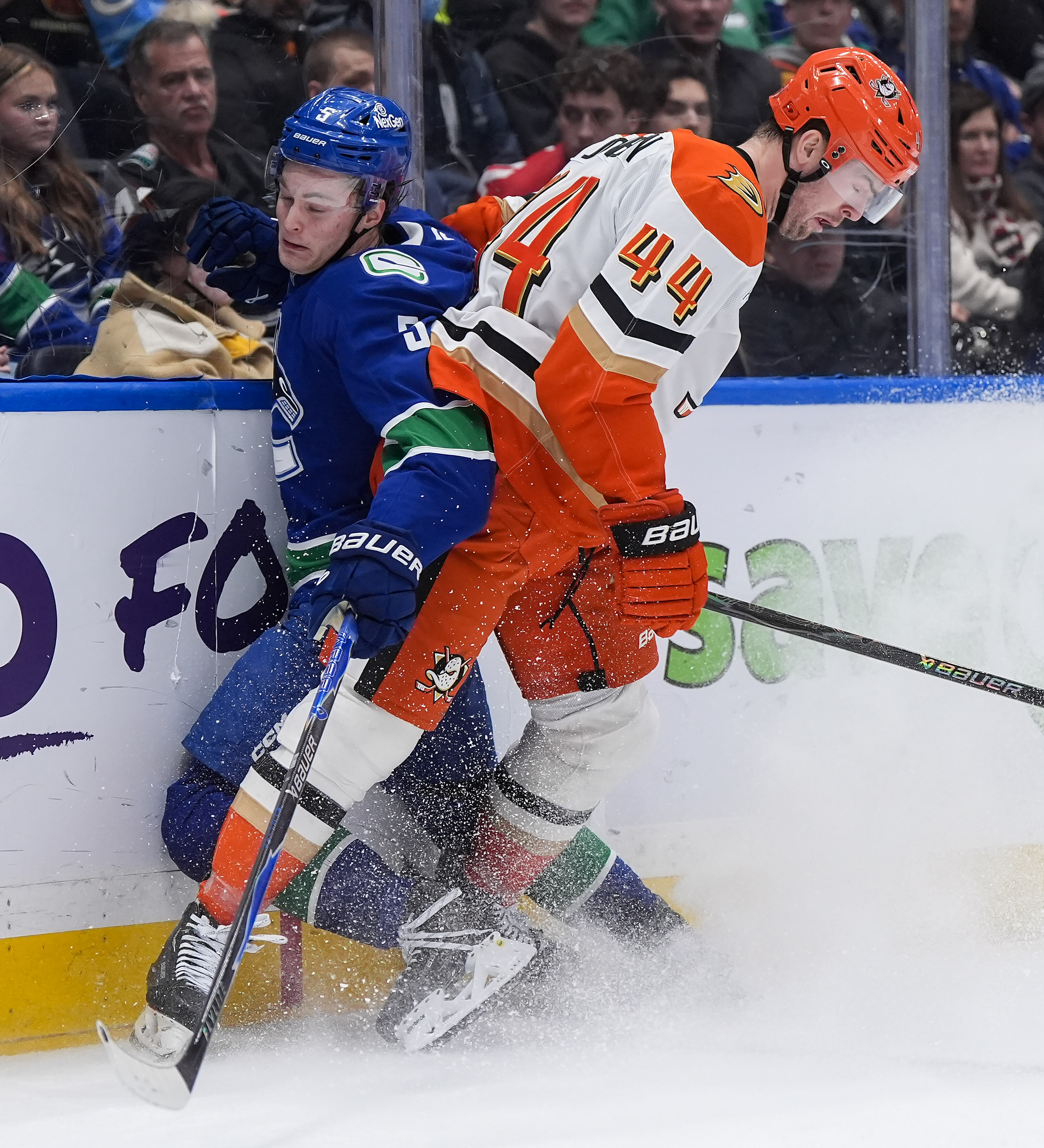 The Ducks’ Ross Johnston, right, checks the Vancouver Canucks’ Tom...