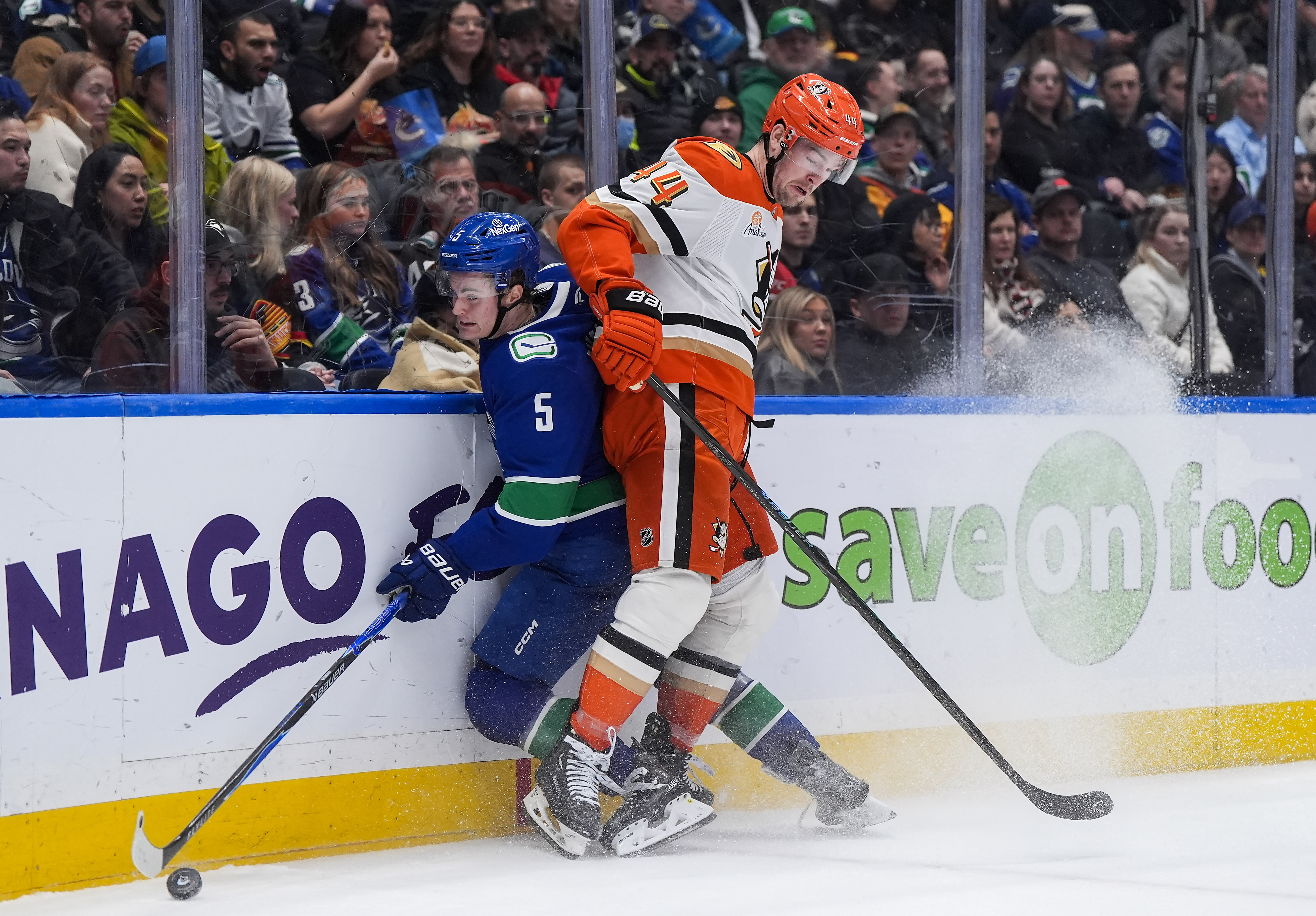 The Ducks’ Ross Johnston, right, checks the Vancouver Canucks’ Tom...