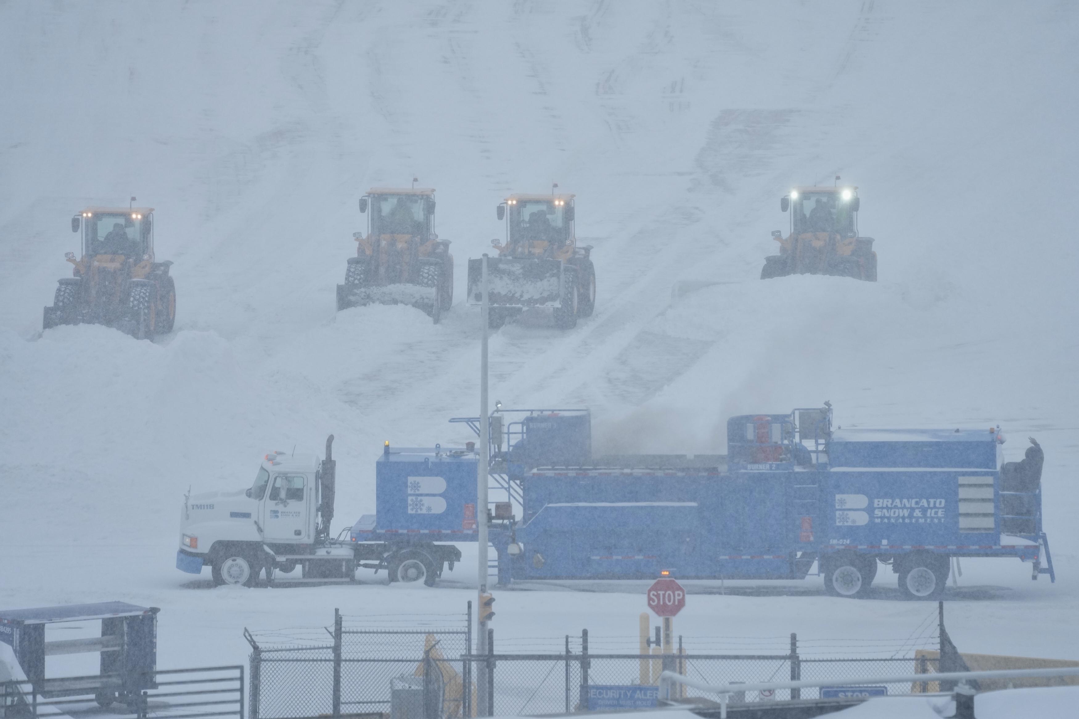 Airport crew plow snow during a winter storm in Philadelphia,...