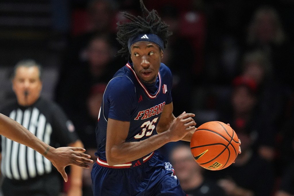 A Fresno State basketball player in a blue jersey with number 35 dribbles the ball.