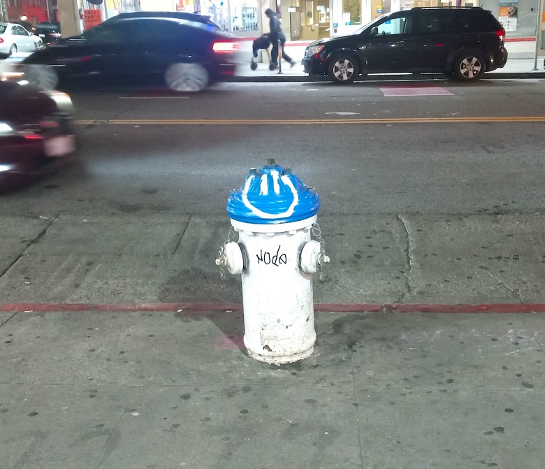 A blue and white fire hydrant on a San Francisco sidewalk. 