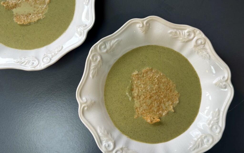 A white bowl of green Broccolini-Parmesan-Soup.