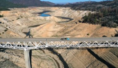 Aerial photo of a bridge over a large, mostly dry lake bed.