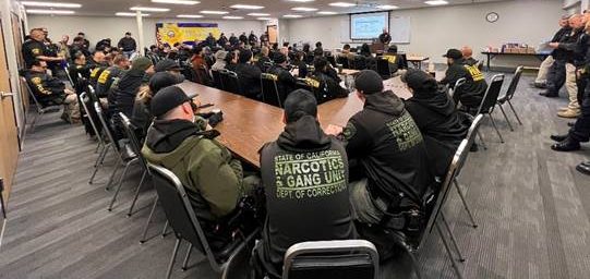 Group photo of various law enforcement agencies as they plan compliance checks on parole supervised people in the Fresno area.