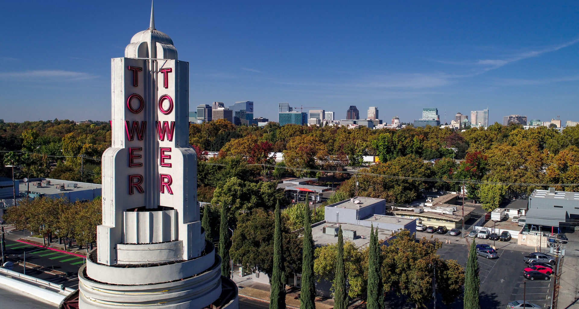 Tower theater with trees in background and skyline