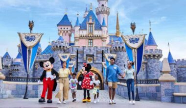Mickey and Minnie walk with a family in front of Sleeping Beauty Castle at Disneyland Park in Anaheim, California.