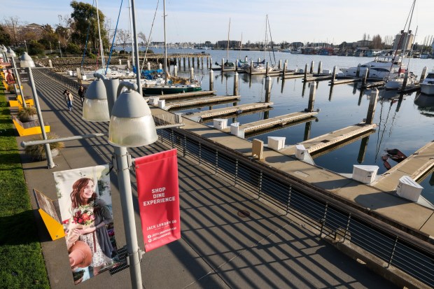 Visitors stroll through a quiet Jack London Square in Oakland, Calif., on Wednesday, Jan. 29, 2026. Once a popular tourist attraction featuring Jack London's cabin, Franklin D. Roosevelt's presidential yacht, restaurants, lawns, a ferry terminal, a waterfront hotel, and amazing views of the Port of Oakland and San Francisco Bay, the area has become an isolated destination marked by vacant storefronts and a shortage of visitors. (Ray Chavez/Bay Area News Group)