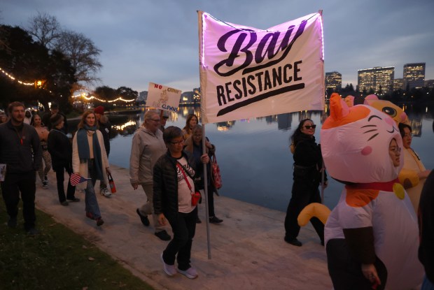 Protesters take part in a march along Lake Merritt in Oakland, Calif., on Monday, Jan. 20, 2026. People took to the streets nationwide in the "Free America Walkout" on the anniversary of President Donald Trump's second inauguration. (Jane Tyska/Bay Area News Group)