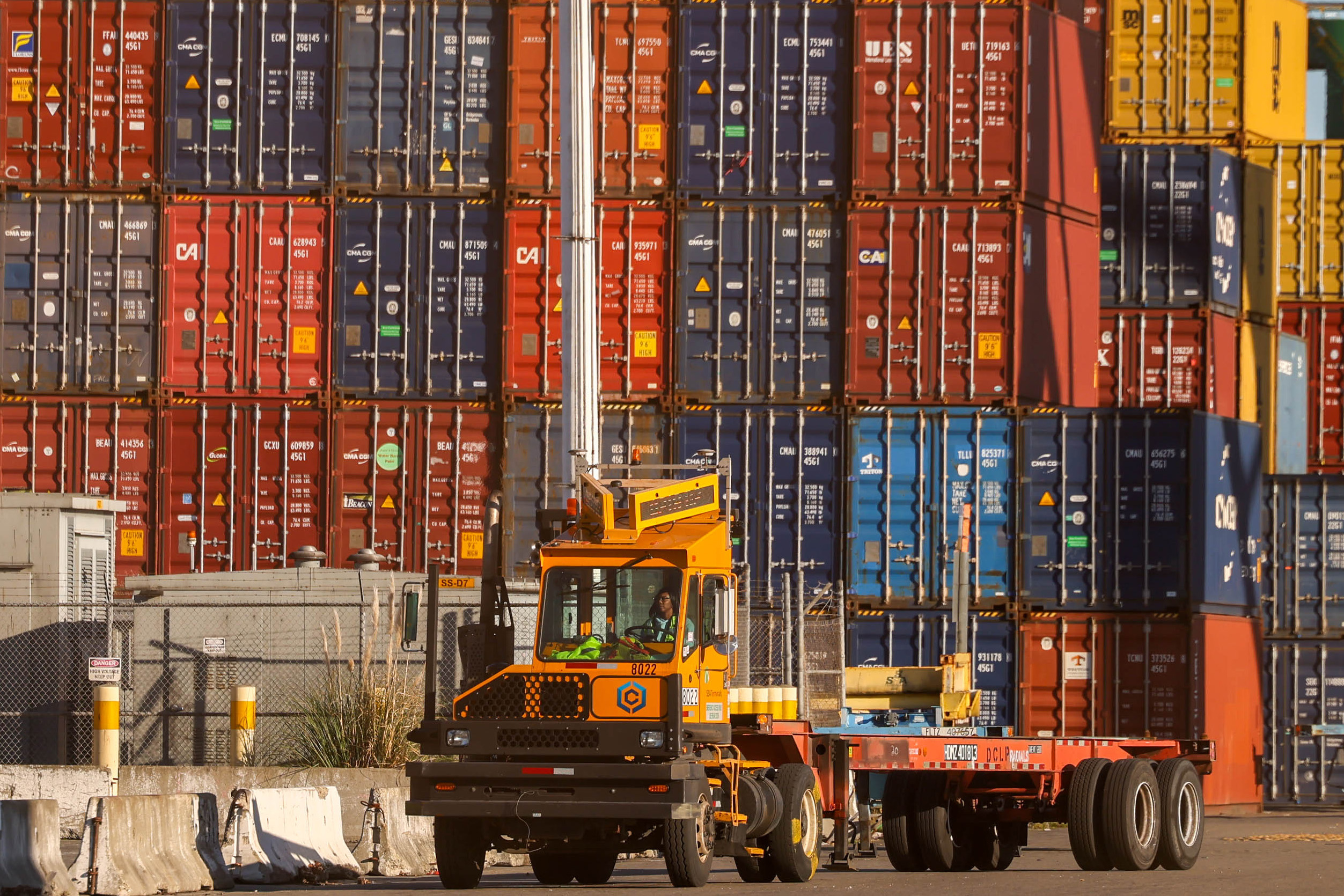 Longshore workers move containers at the Port of Oakland in...