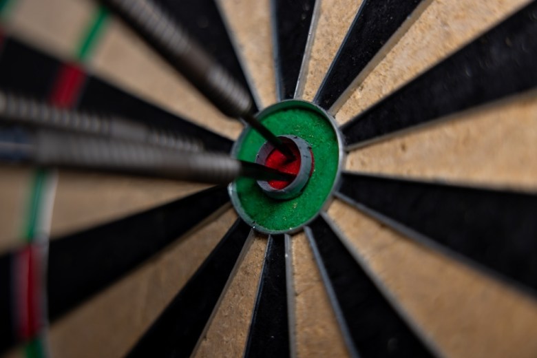Dart board with two darts in the bullseye.