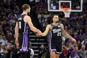 SACRAMENTO, CALIFORNIA - JANUARY 03: Devin Carter #22 of the Sacramento Kings high-fives Domantas Sabonis #11 in the first half of their game against the Memphis Grizzlies at Golden 1 Center on January 03, 2025 in Sacramento, California. Carter is making his NBA debut in tonight's game. NOTE TO USER: User expressly acknowledges and agrees that, by downloading and/or using this photograph, user is consenting to the terms and conditions of the Getty Images License Agreement. (Photo by Ezra Shaw/Getty Images)