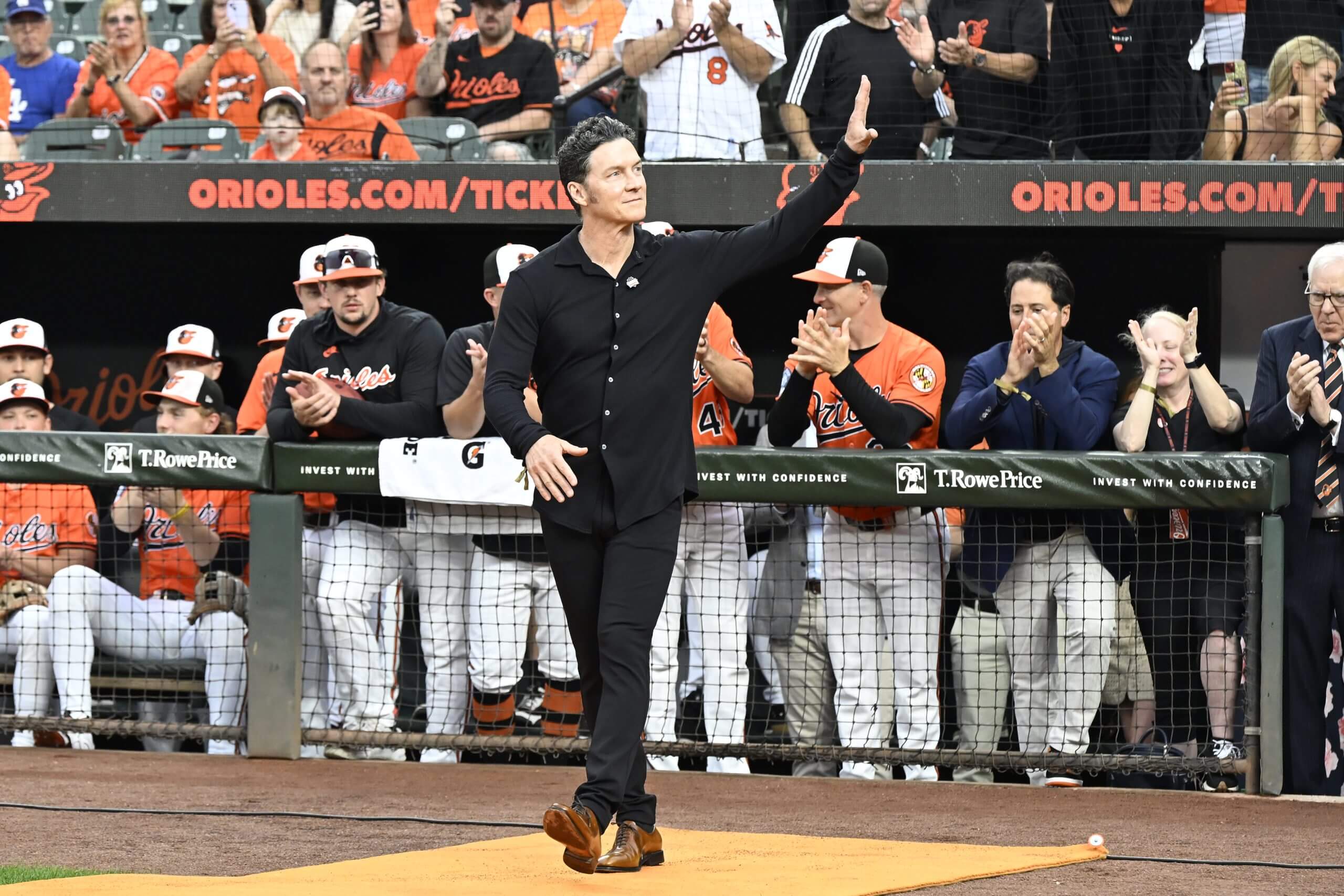 Brady Anderson waves to the crowd after walking out of the dugout during a ceremony celebrating the 30th anniversary of Cal Ripken Jr.'s record for consecutive games played.