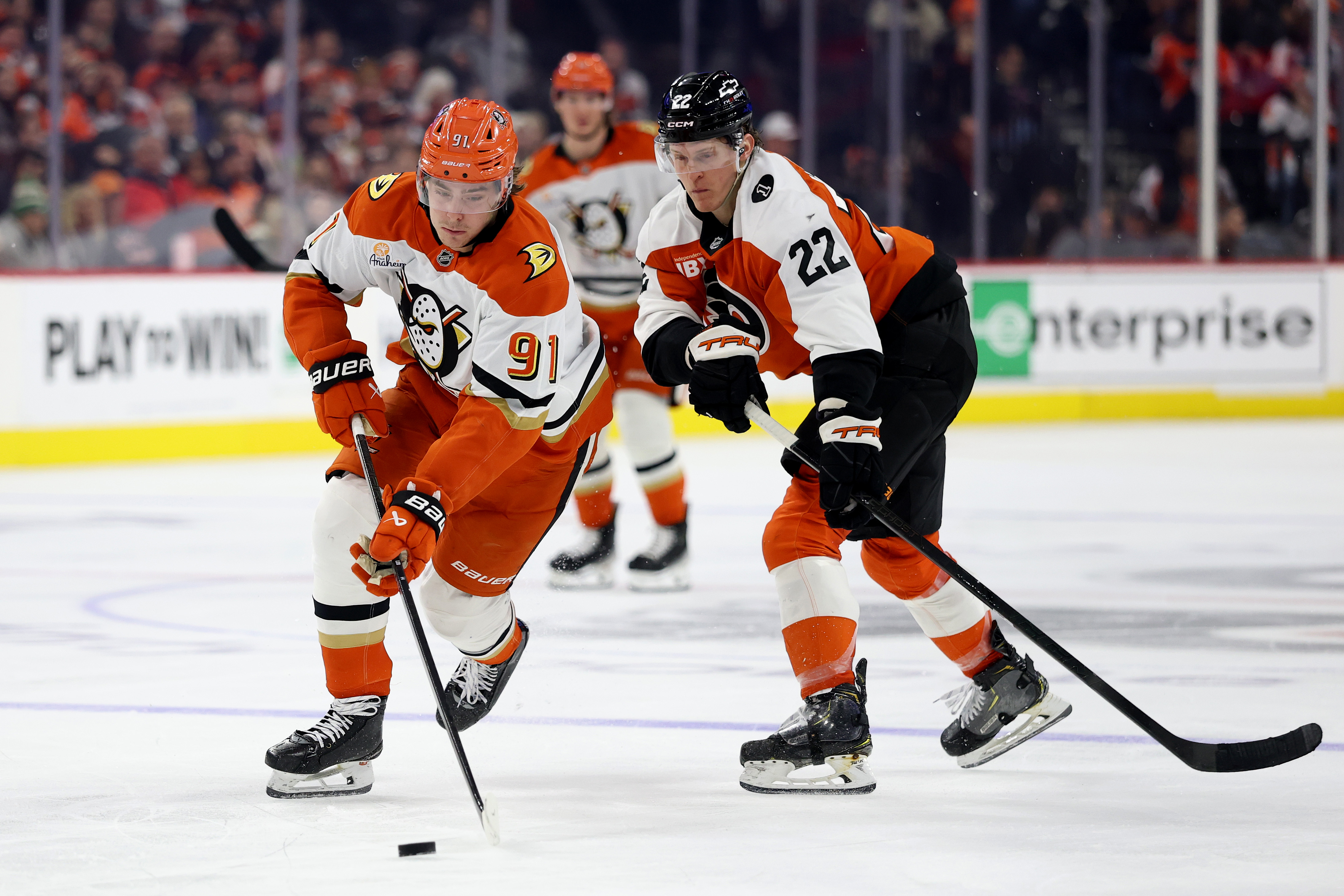 Ducks center Leo Carlsson, left, controls the puck as the...