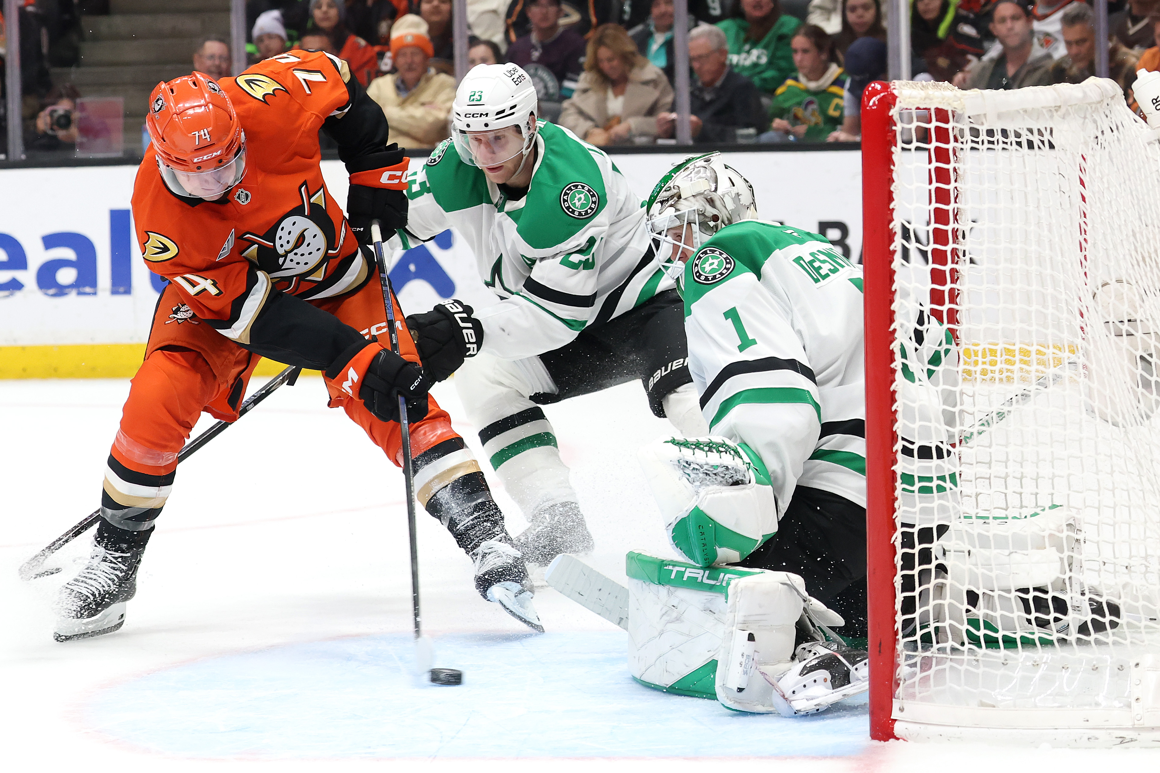 The Ducks’ Ian Moore, left, takes a shot on goal...