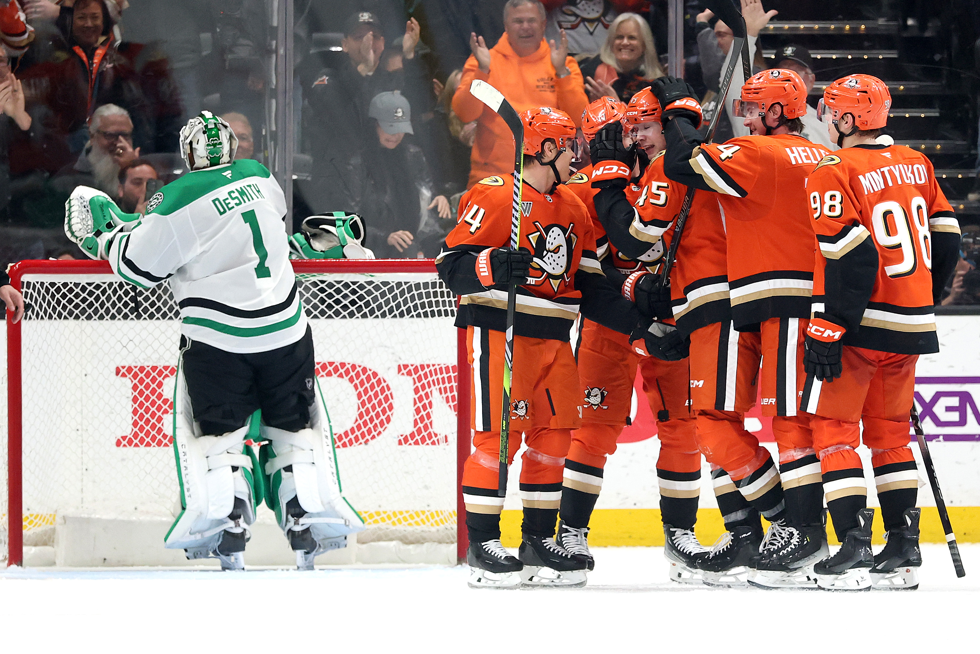 The Ducks’ Drew Helleson (14), Pavel Mintyukov (98) and Mikael...