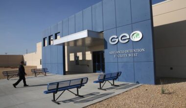 On a modern, low-slung building with no windows, a big sign reading 'GEO' hangs on an exterior wall.