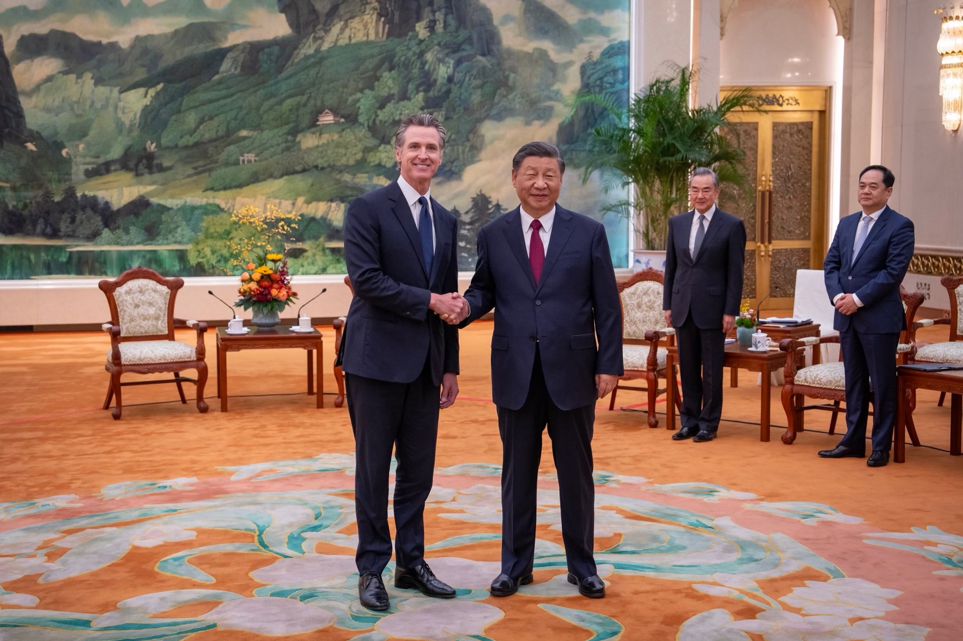 Gavin Newsom and Xi Jinping shake hands in a conference room 