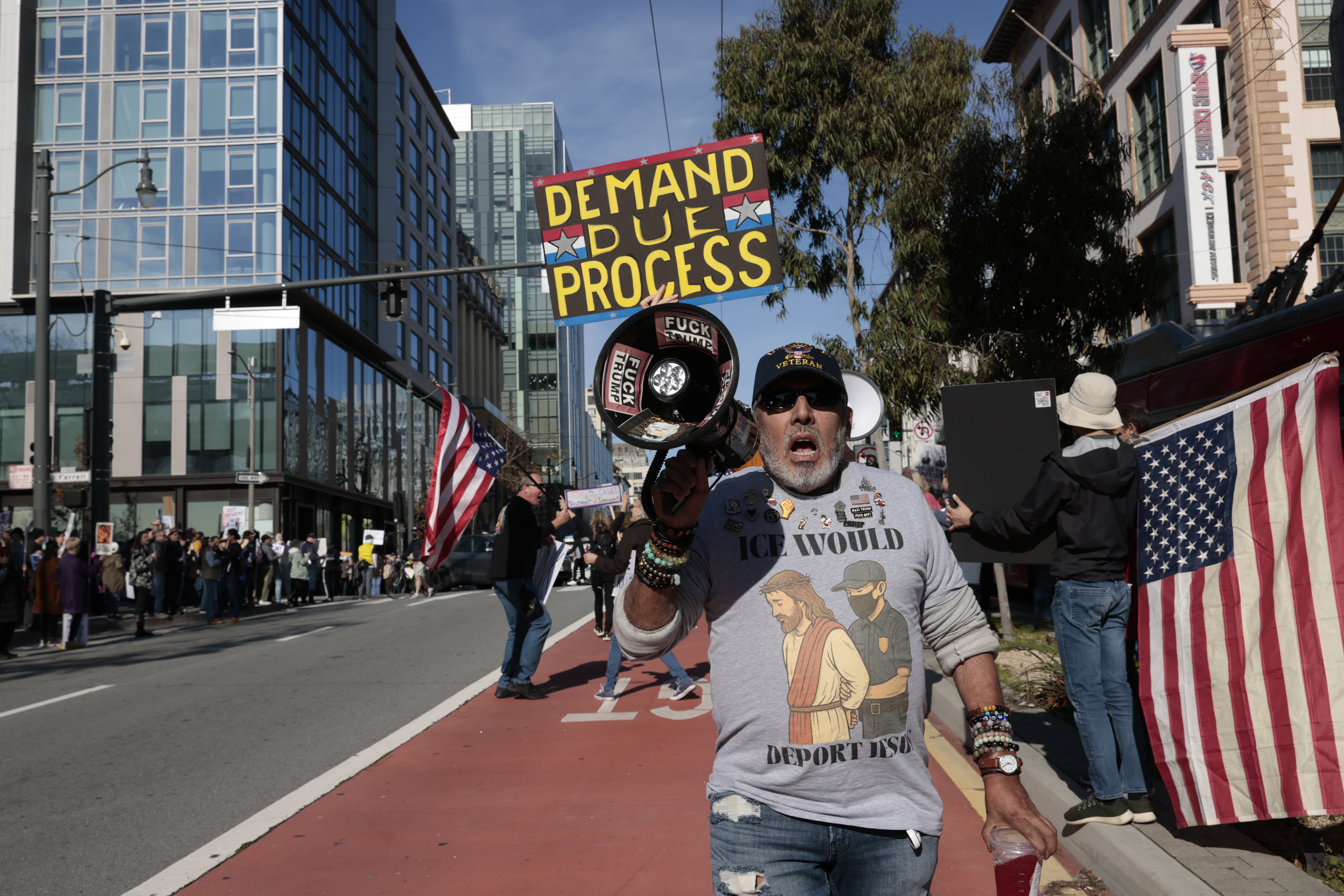 People protest outside the Tesla showroom against immigration enforcement and...