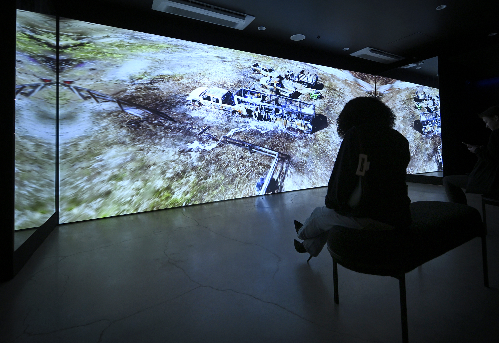 A woman looks at a projection of a burned out...