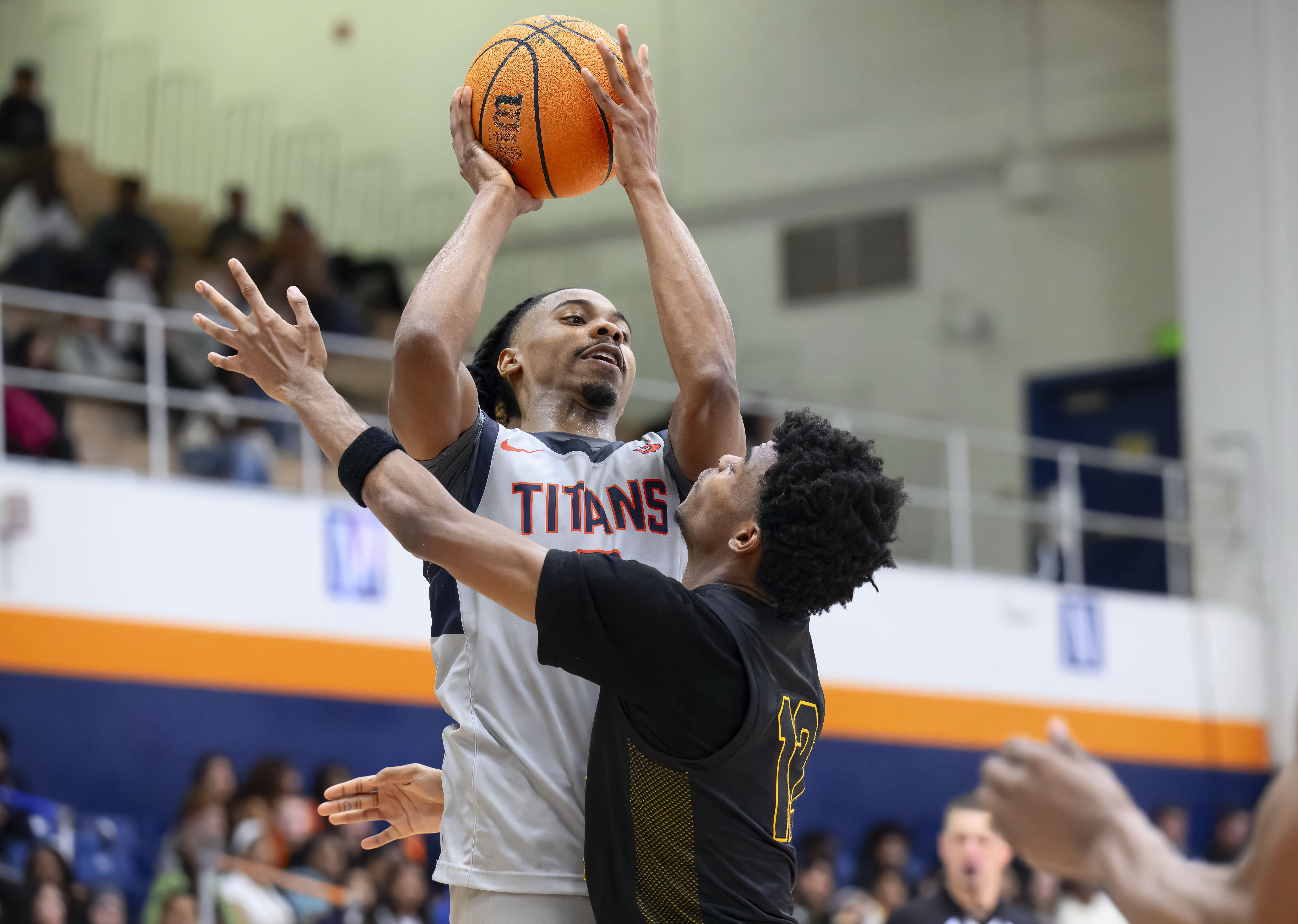 Cal State Fullerton guard Josh Ward, left, fakes a shot...
