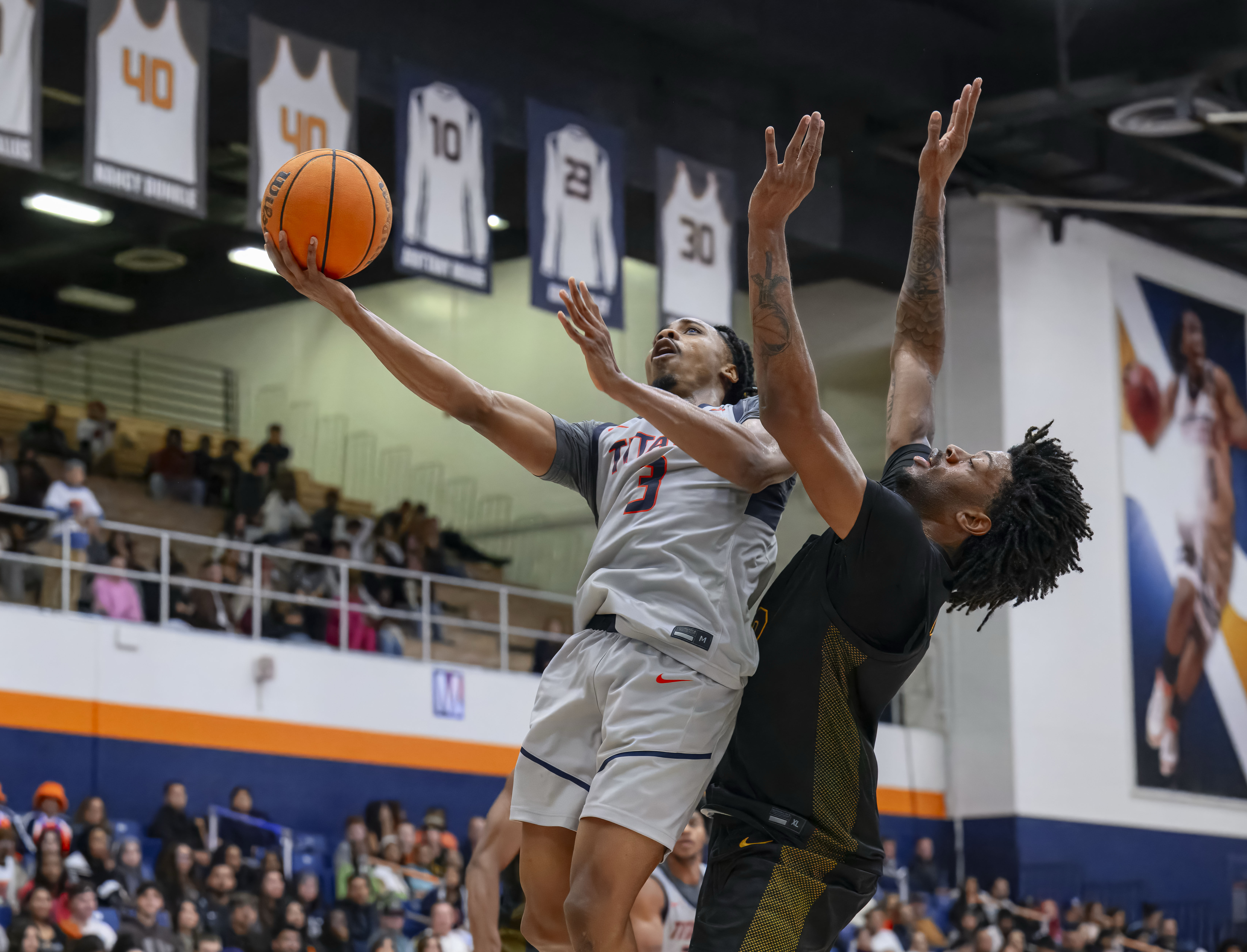 Cal State Fullerton guard Josh Ward, left, gets in front...