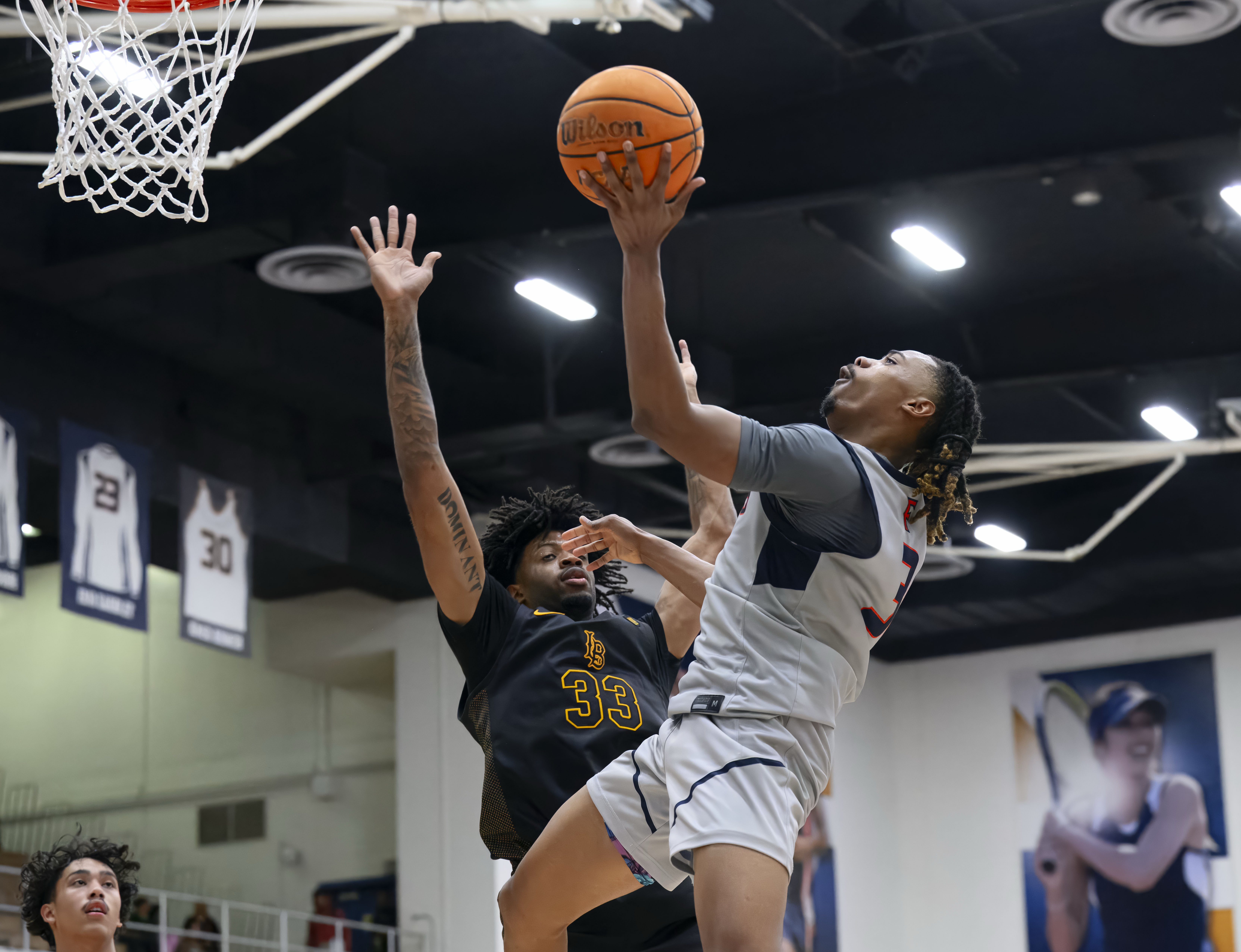 Cal State Fullerton guard Josh Ward, right, shoots over Long...