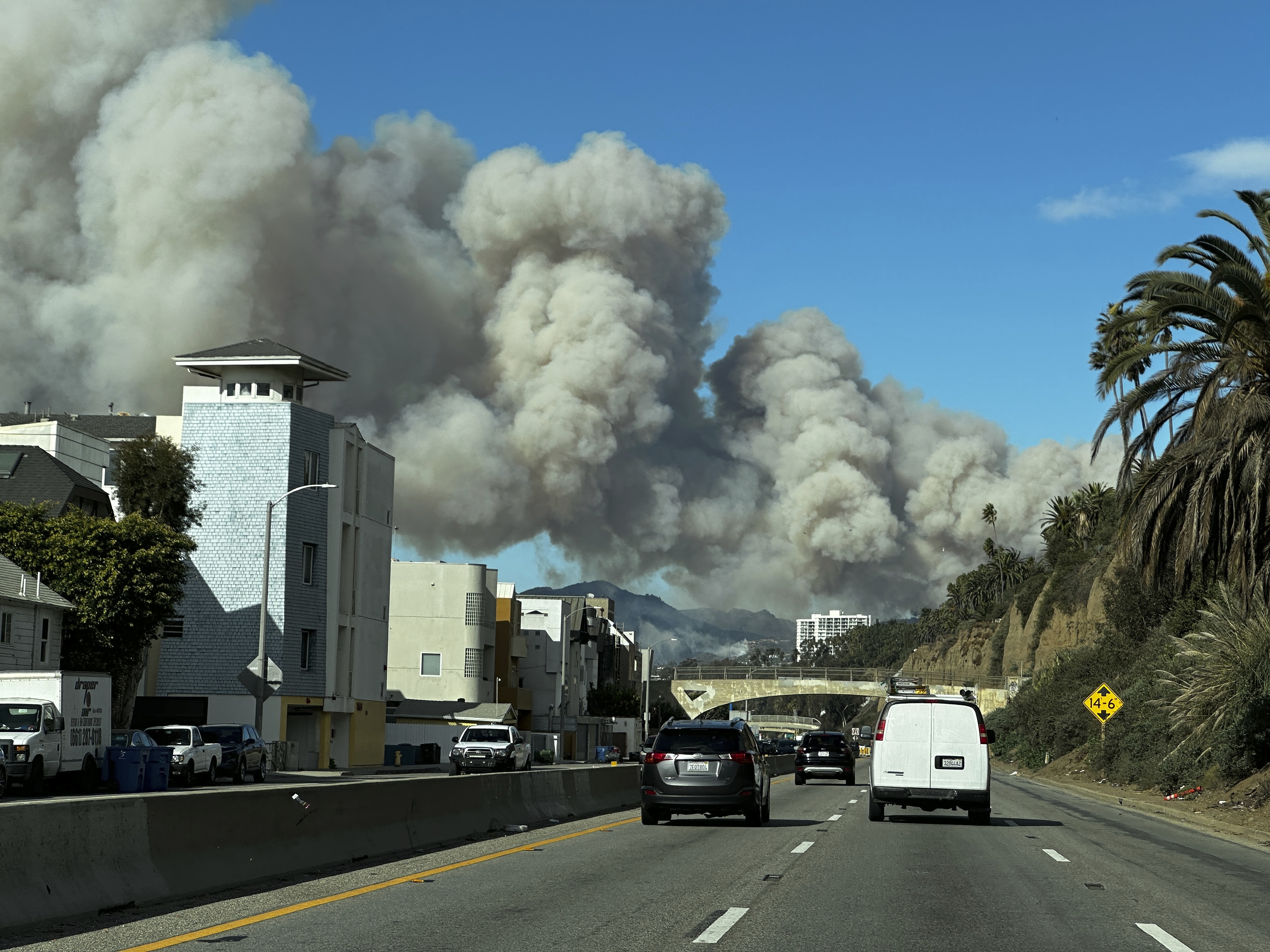 Smoke from the Palisades fire rises over Pacific Coast Highway...