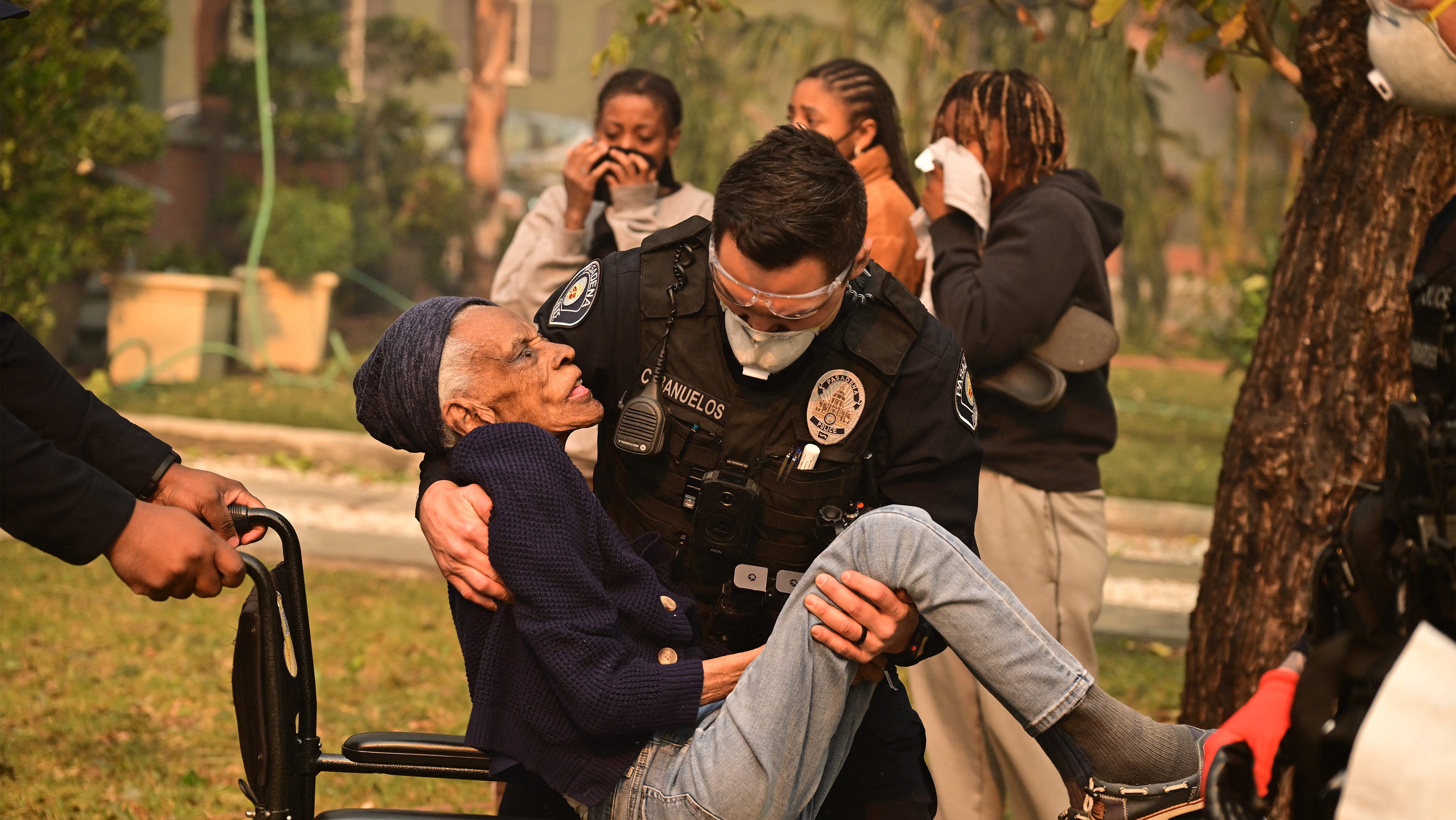 Police officers evacuate a senior from her home during the...