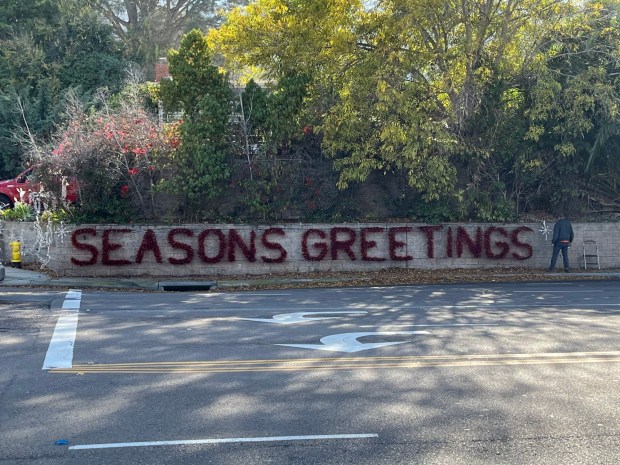 The traditional "Season's greetings" sign is placed in front of La Jolla resident Dan Courtney's home near the corner of Torrey Pines Road and La Jolla Shores Drive. (Noah Lyons)