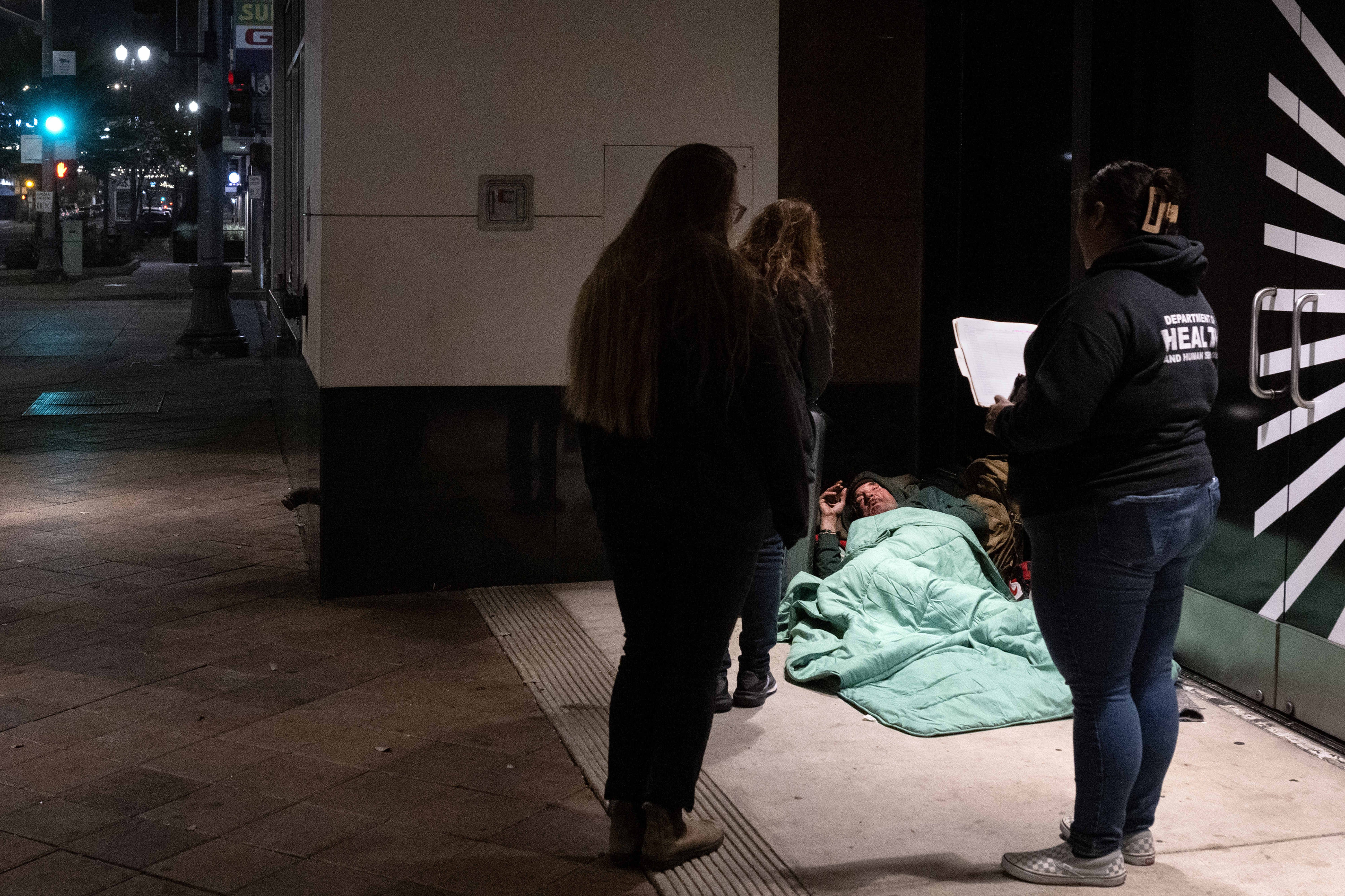 Volunteers approach a person experiencing homelessness during the 2026 Point...