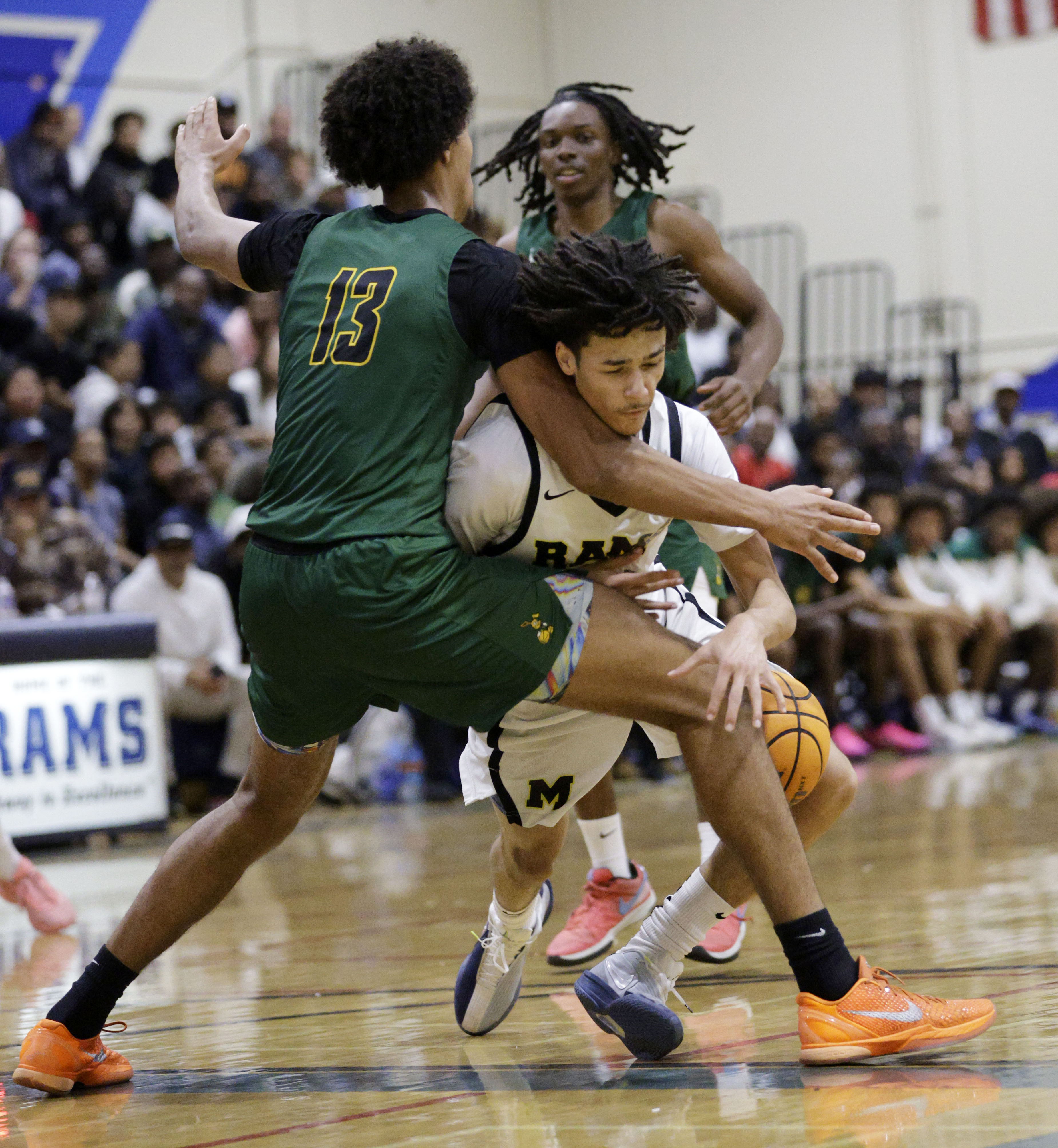 Long Beach Poly’s Jonas Oware (13) puts the pressure on...