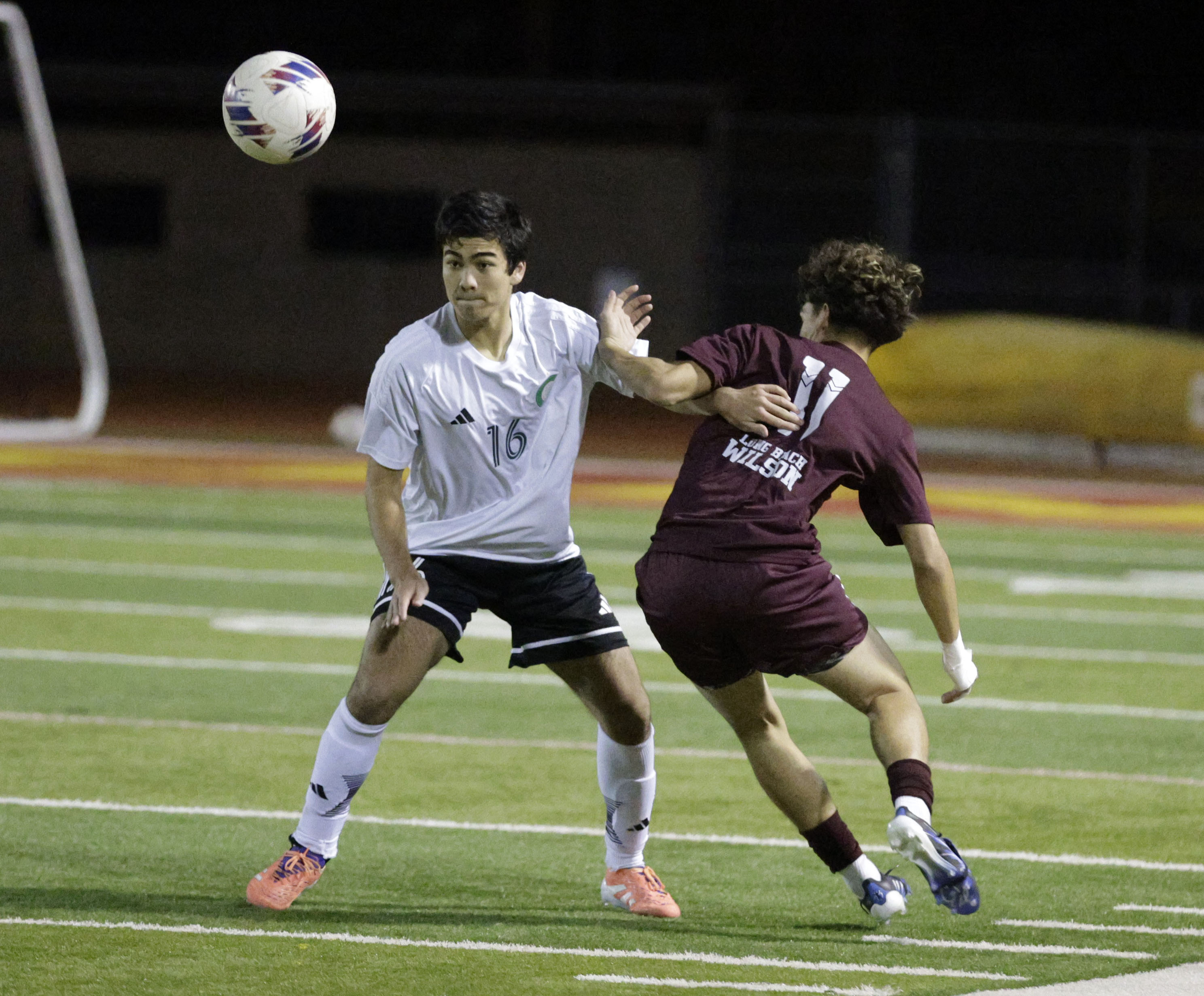 Long Beach Poly’s Jonah Gershenson (16) heads the ball away...