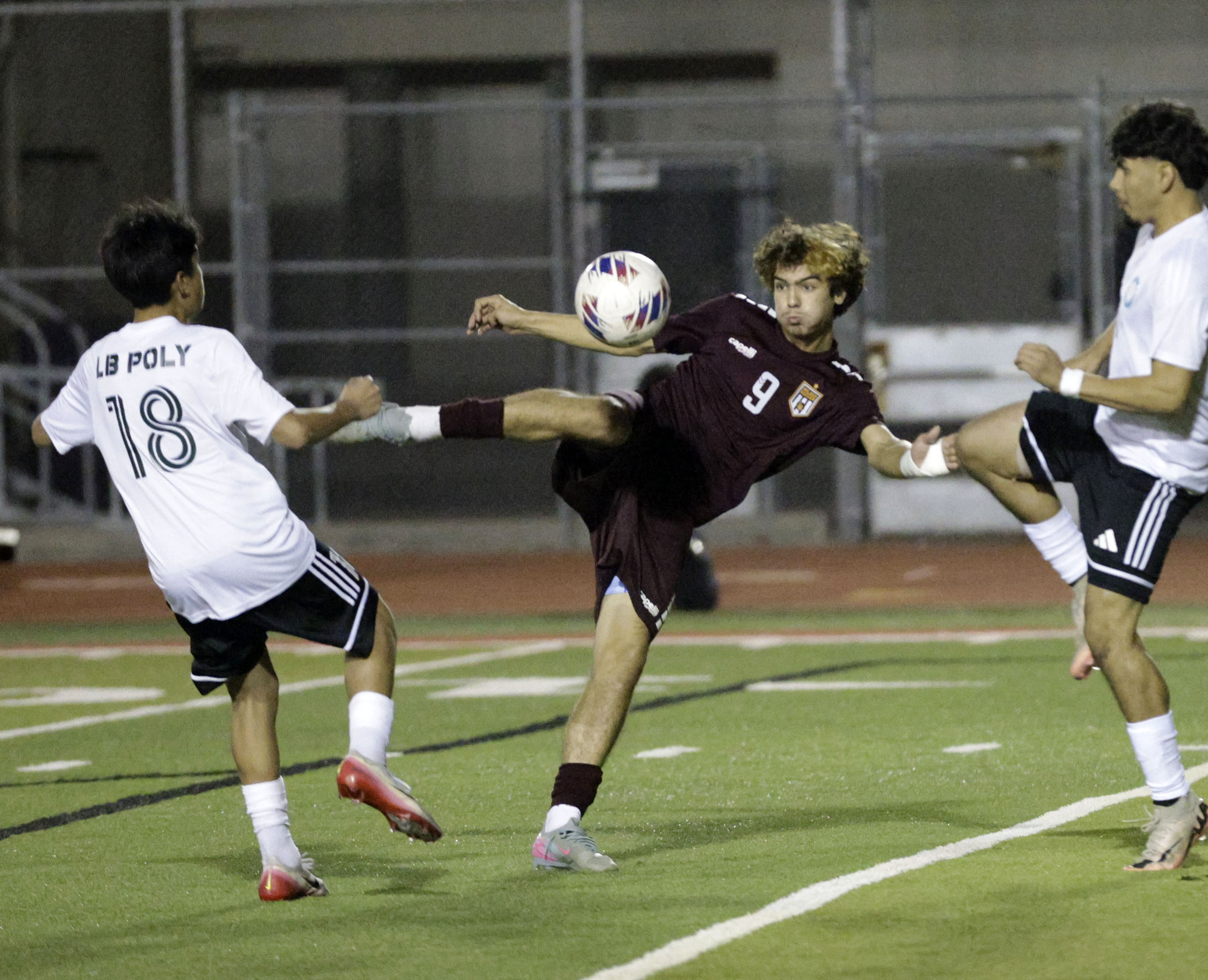 Wilson’s Casey Pettyjohn (9) kicks the ball away from Long...